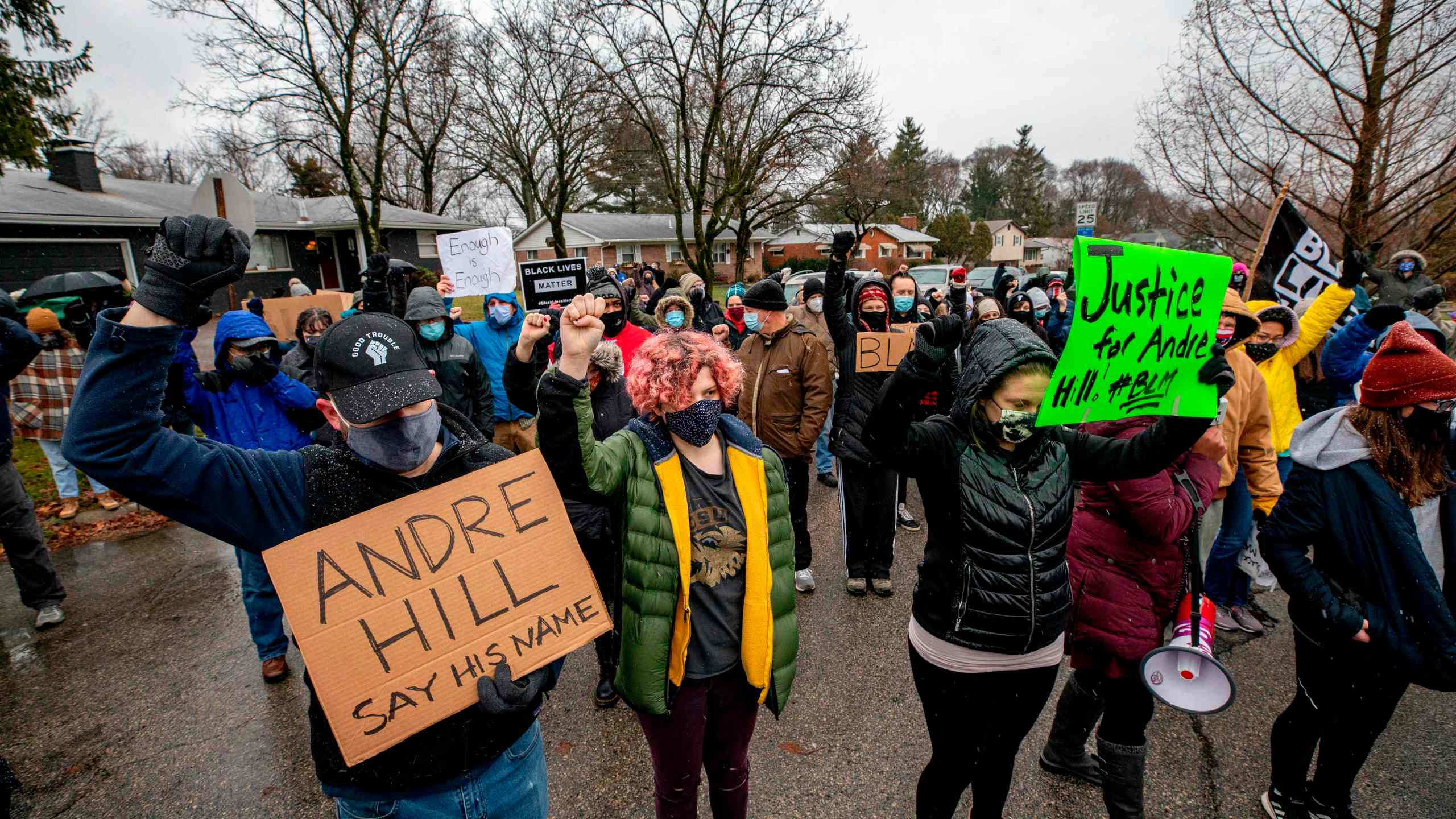 Protesters raise their fists and observe a moment of silence on Dec. 24, 2020, during a demonstration against the police killing of Andre Hill in Columbus, Ohio. (STEPHEN ZENNER/AFP via Getty Images)