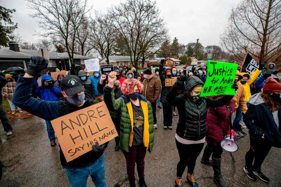 Protesters raise their fists and observe a moment of silence on Dec. 24, 2020, during a demonstration against the police killing of Andre Hill in Columbus, Ohio. (STEPHEN ZENNER/AFP via Getty Images)