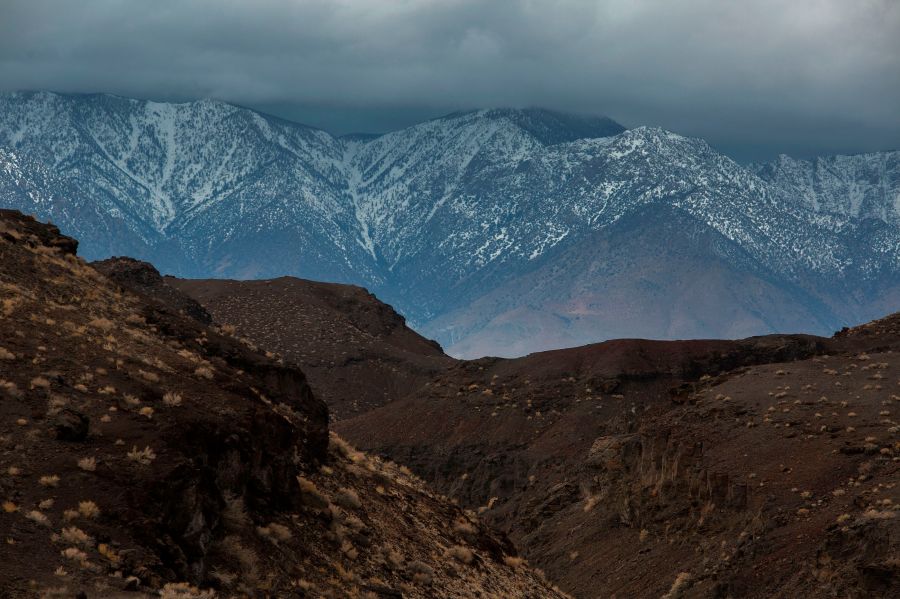 A volcanic desert landscape is seen with snowy Eastern Sierra Nevada Mountains in the distance near Lone Pine, California, January 8, 2017 as a series of strong storms moves into California. (David McNew/AFP via Getty Images)