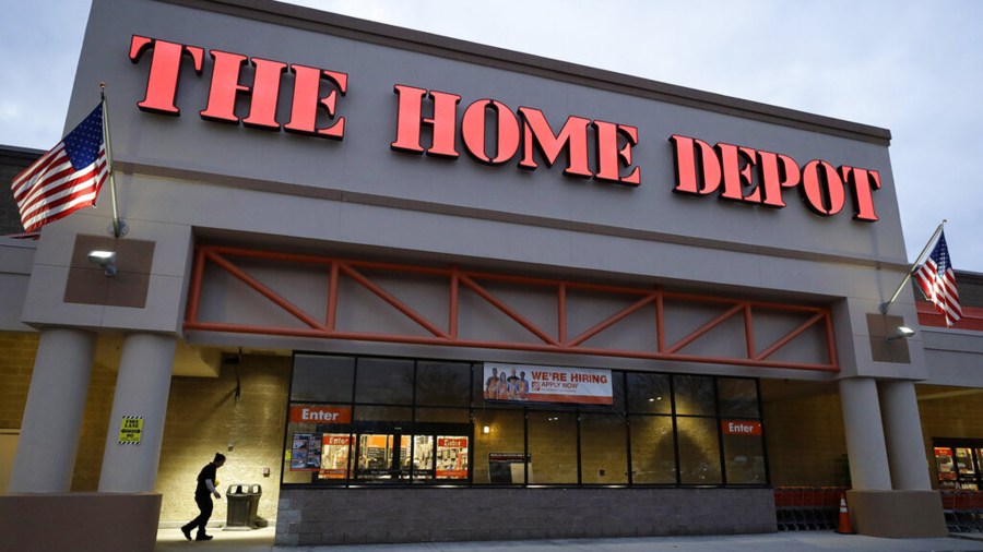 In this Jan. 27, 2020 file photo a passer-by, below left, walks toward an entrance to a Home Depot store location, in Boston. (Steven Senne/Associated Press)