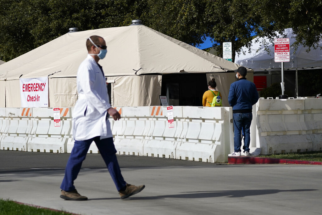 A medical worker passes a tent outside the emergency room at UCI Medical Center in Irvine, Calif. (AP Photo/Ashley Landis, File)