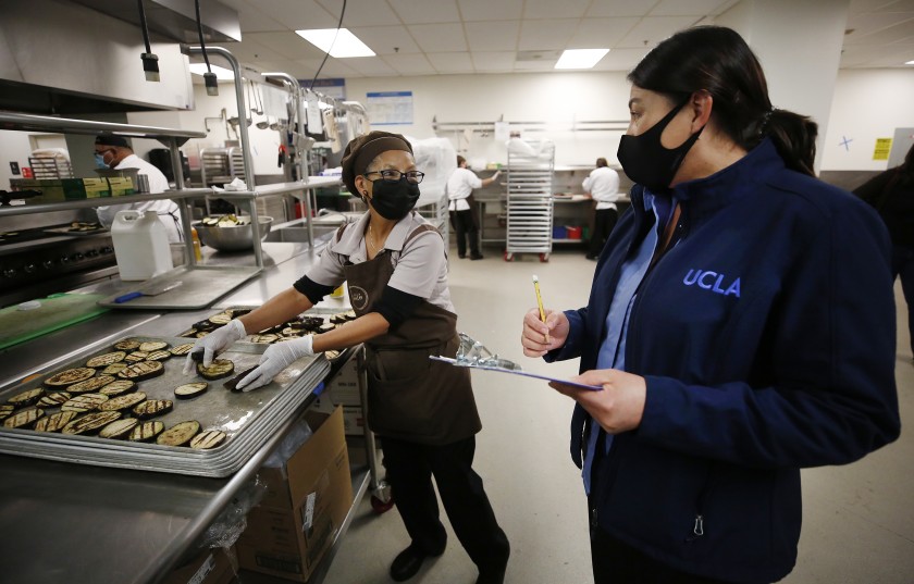 UCLA is grappling with the pandemic’s financial fallout in part by redeploying workers, such as those in food service who are now making meals for low-income families as campus demand has plunged. (Al Seib / Los Angeles Times)