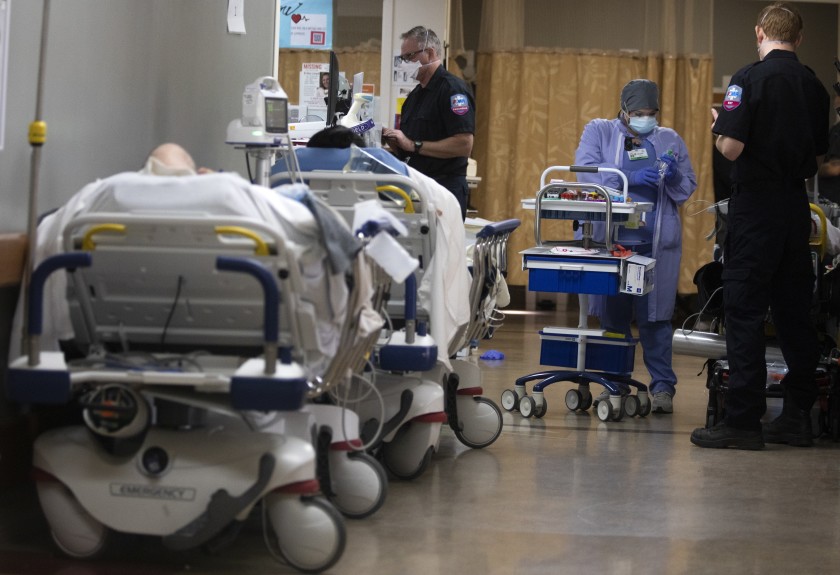 Melissa Quintero takes blood from a patient inside a hallway in the emergency department at Providence St. Mary Medical Center in Apple Valley. The medical center is currently receiving support from the California National Guard. (Francine Orr / Los Angeles Times)