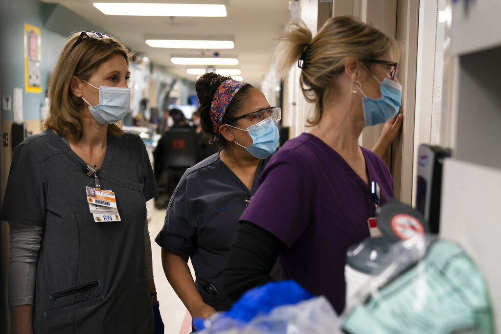 Health care workers watch as medical workers try to resuscitate a patient who tested positive for coronavirus at Providence Holy Cross Medical Center in the Mission Hills area of Los Angeles. (AP Photo/Jae C. Hong, File)