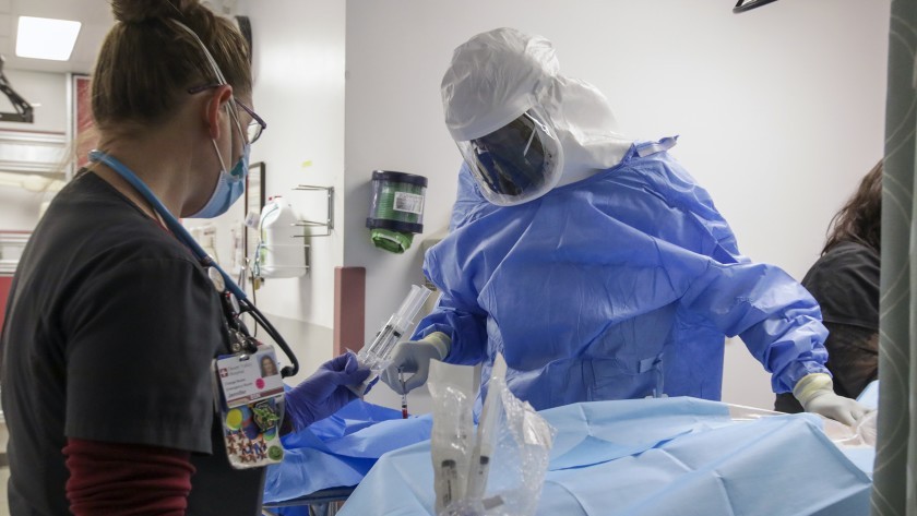 ER nurse Jennifer Caspary, left, and emergency department medical director Dr. Leroy Pascal attend to a COVID-19 patient at Desert Valley Hospital in Victorville on Dec. 17.(Irfan Khan / Los Angeles Times)