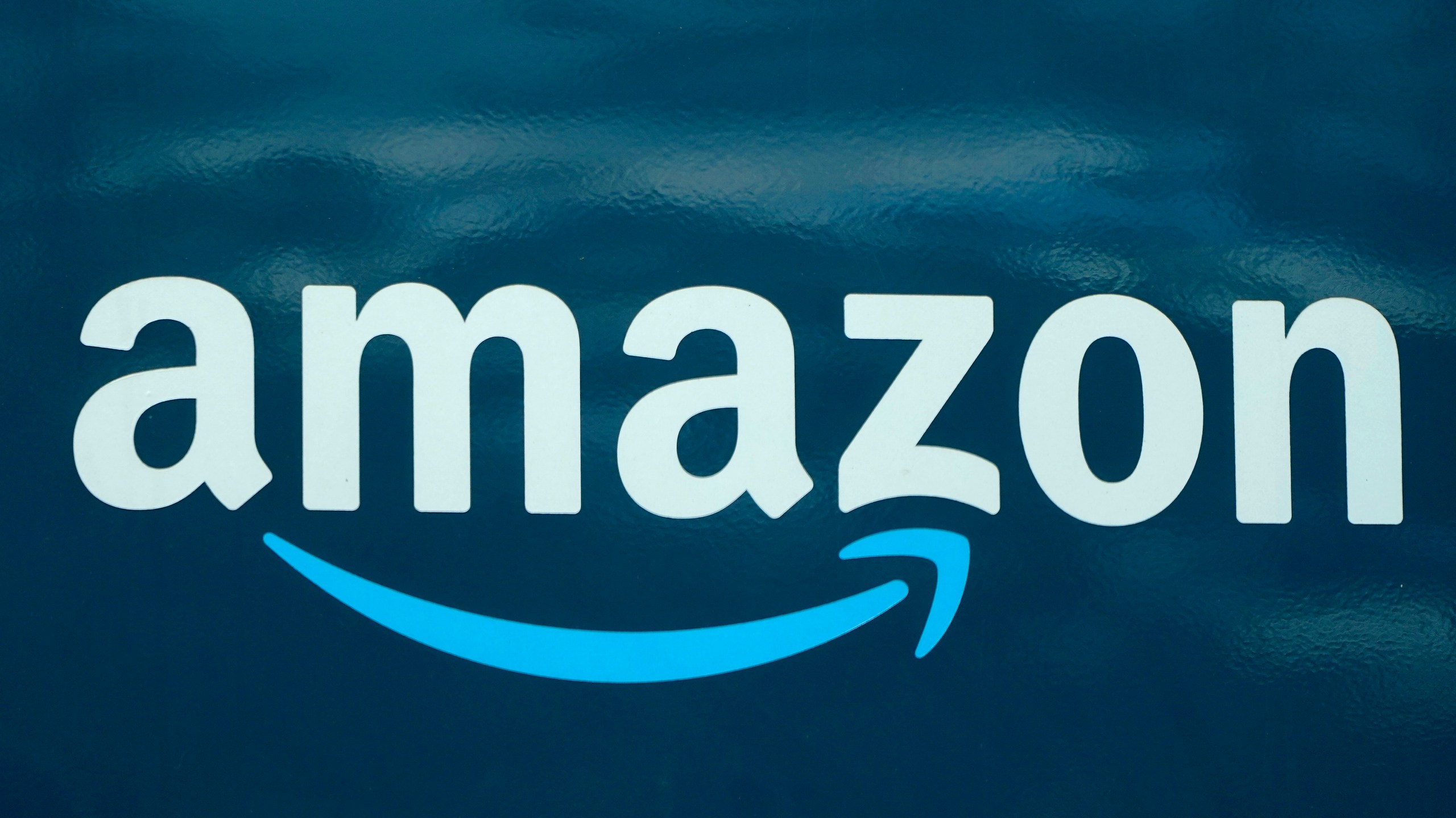 An Amazon logo appears on an Amazon delivery van, Thursday, Oct. 1, 2020, in Boston. Amazon said Tuesday, Jan. 5, 2021, that it bought 11 jets from Delta and WestJet airlines to boost its growing delivery network and get orders to shoppers faster. (Steven Senne/AP Photo)