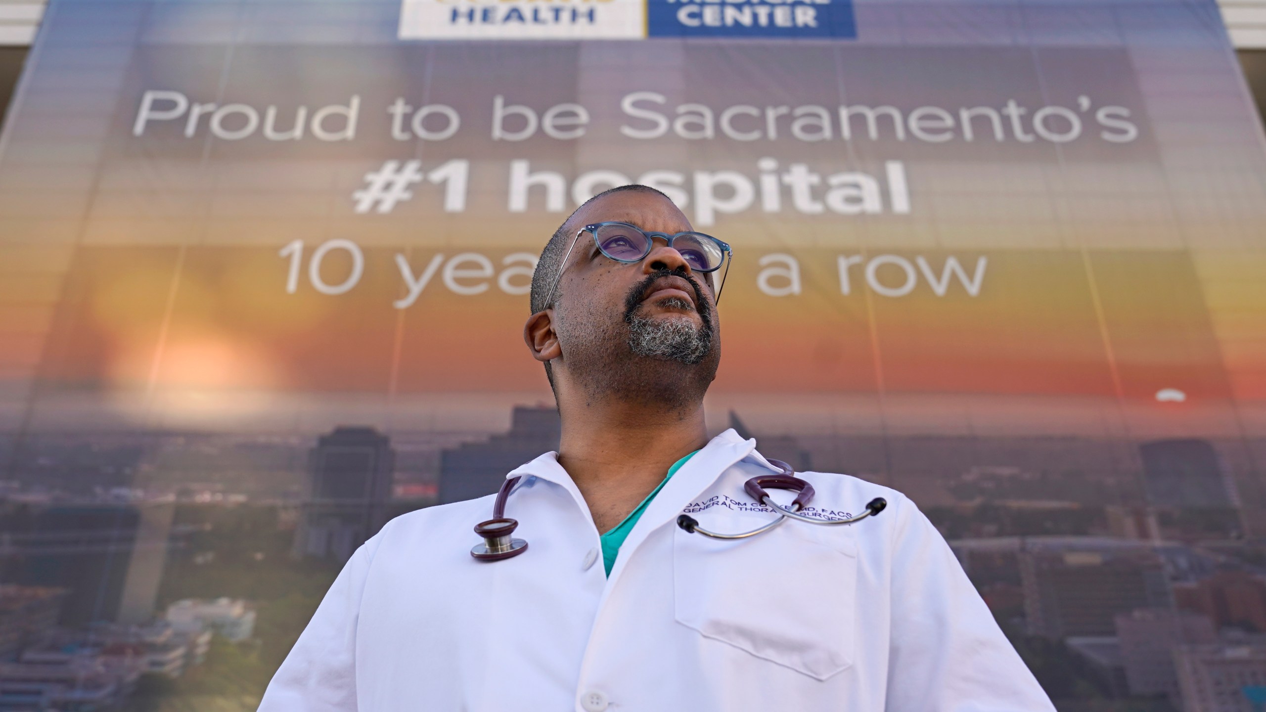 Dr. David Tom Cooke, head of general thoracic surgery at UC Davis Health, poses outside the UC Davis Medical center in Sacramento, Calif., Friday, Dec. 18, 2020. Cooke participated in Pfizer's clinical trial for the coronavirus as part of an effort to reduce skepticism about the vaccine among the Black community. He's now promoting the vaccine's safety and the importance of taking it on his social media pages. (AP Photo/Rich Pedroncelli)