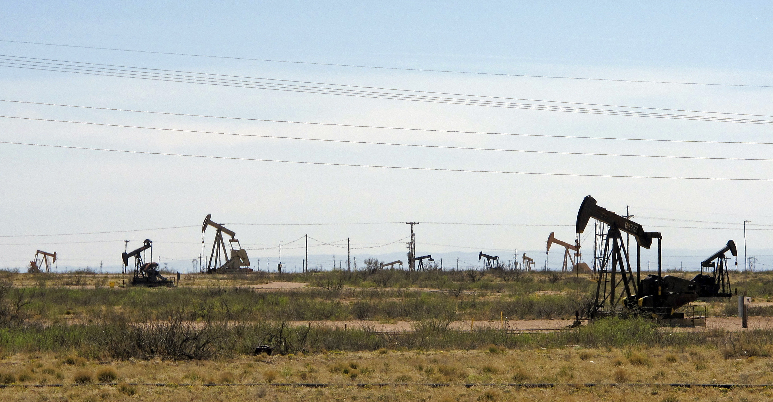 In this April 9, 2014, file photo, oil rigs stand in the Loco Hills field on U.S. Highway 82 in Eddy County near Artesia, N.M., one of the most active regions of the Permian Basin. President Joe Biden is set to announce a wide-ranging moratorium on new oil and gas leasing on U.S. lands, as his administration moves quickly to reverse Trump administration policies on energy and the environment and address climate change. (AP Photo/Jeri Clausing, File)