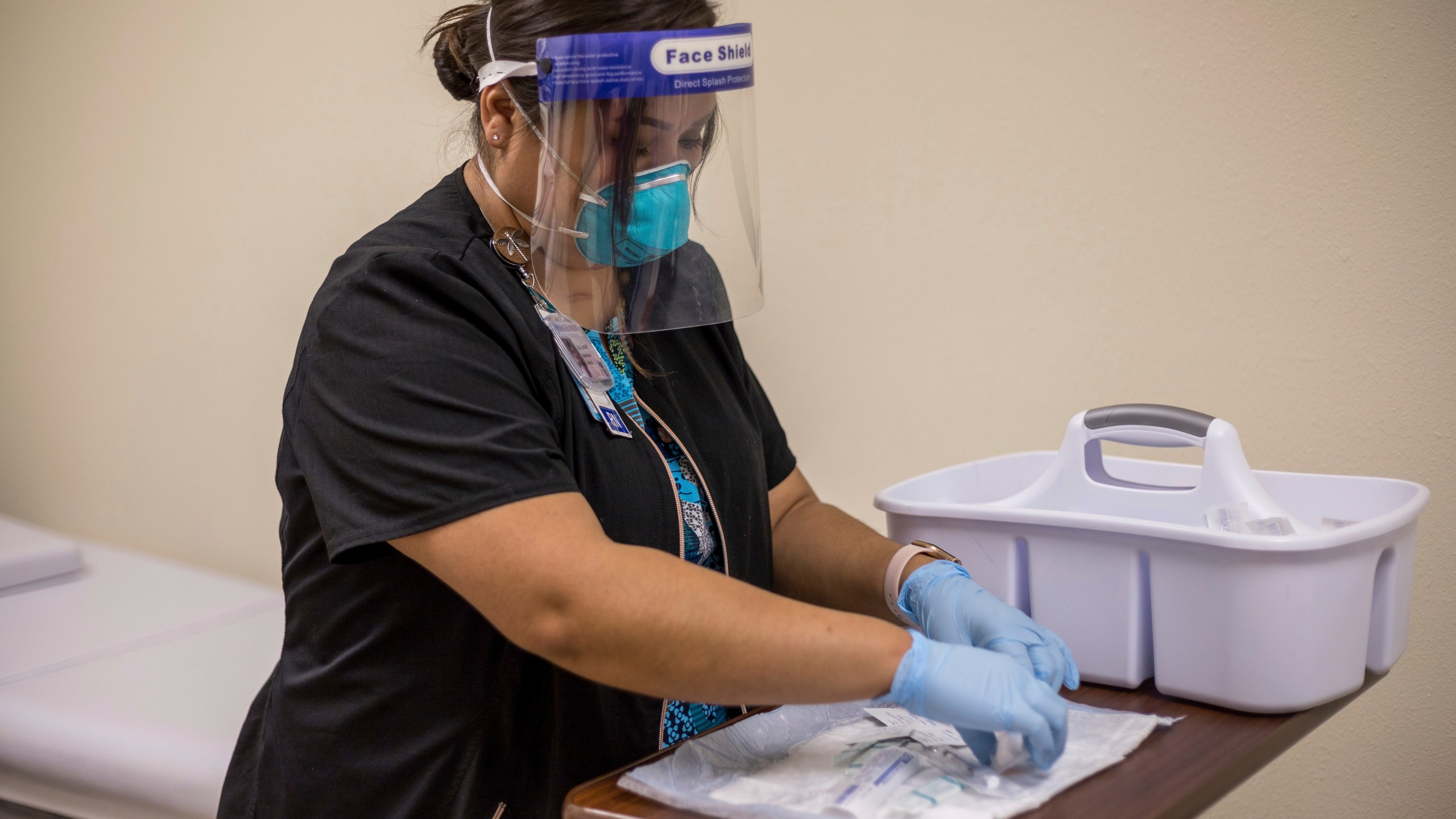 In this Tuesday, Dec. 29, 2020, photo provided by Johns Hopkins Center for American Indian Health, registered nurse Starla Garcia prepares a coronavirus vaccine in Chinle, Ariz., for someone who enrolled in the COVID-19 vaccine trials on the Navajo Nation and initially received a placebo. (Nina Mayer Ritchie/Johns Hopkins Center for American Indian Health via AP)