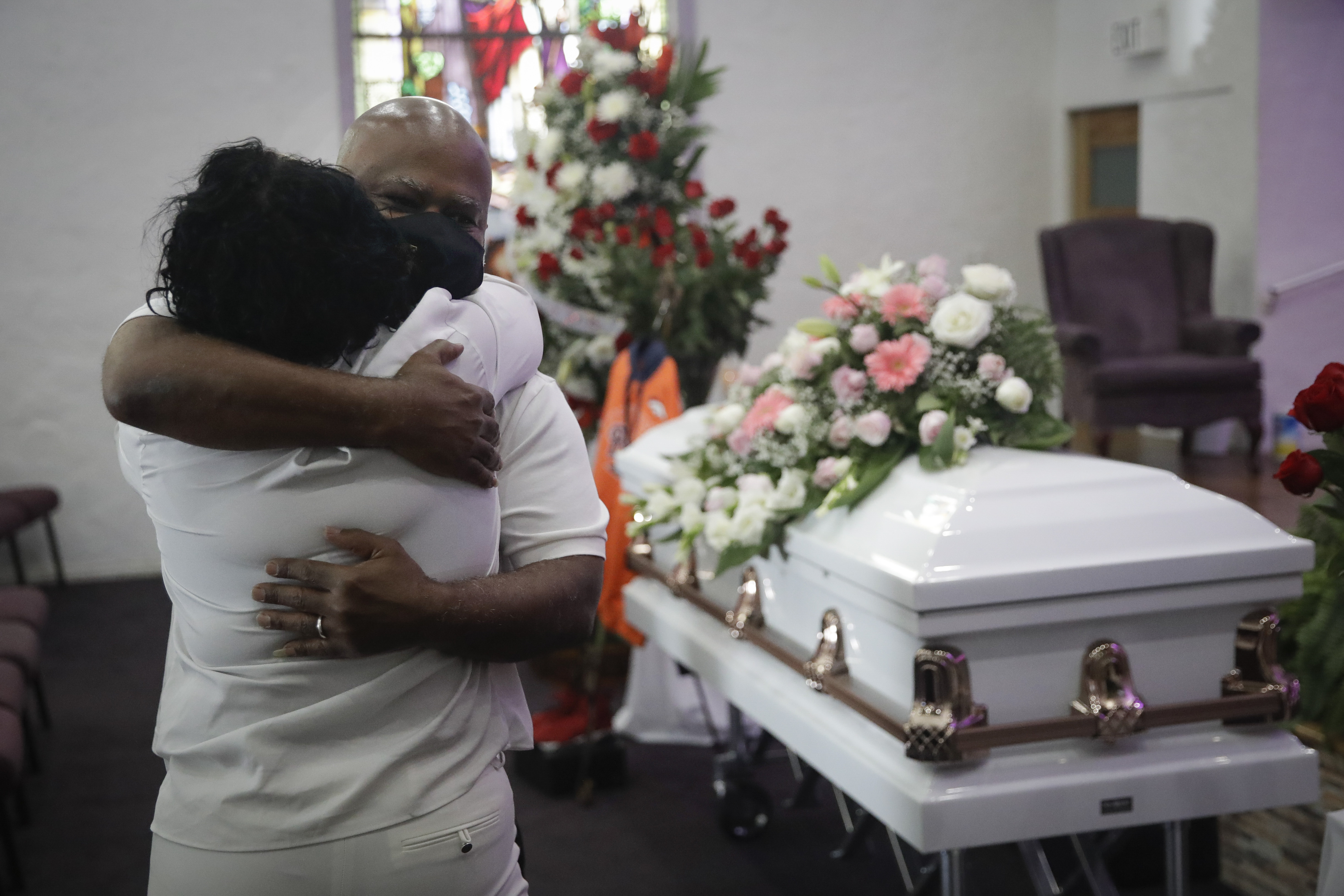 In this July 21, 2020, file photo, Darryl Hutchinson, facing camera, is hugged by a relative during a funeral service for Lydia Nunez, who was Hutchinson's cousin at the Metropolitan Baptist Church in Los Angeles. Nunez died from COVID-19. (AP Photo/Marcio Jose Sanchez, File)