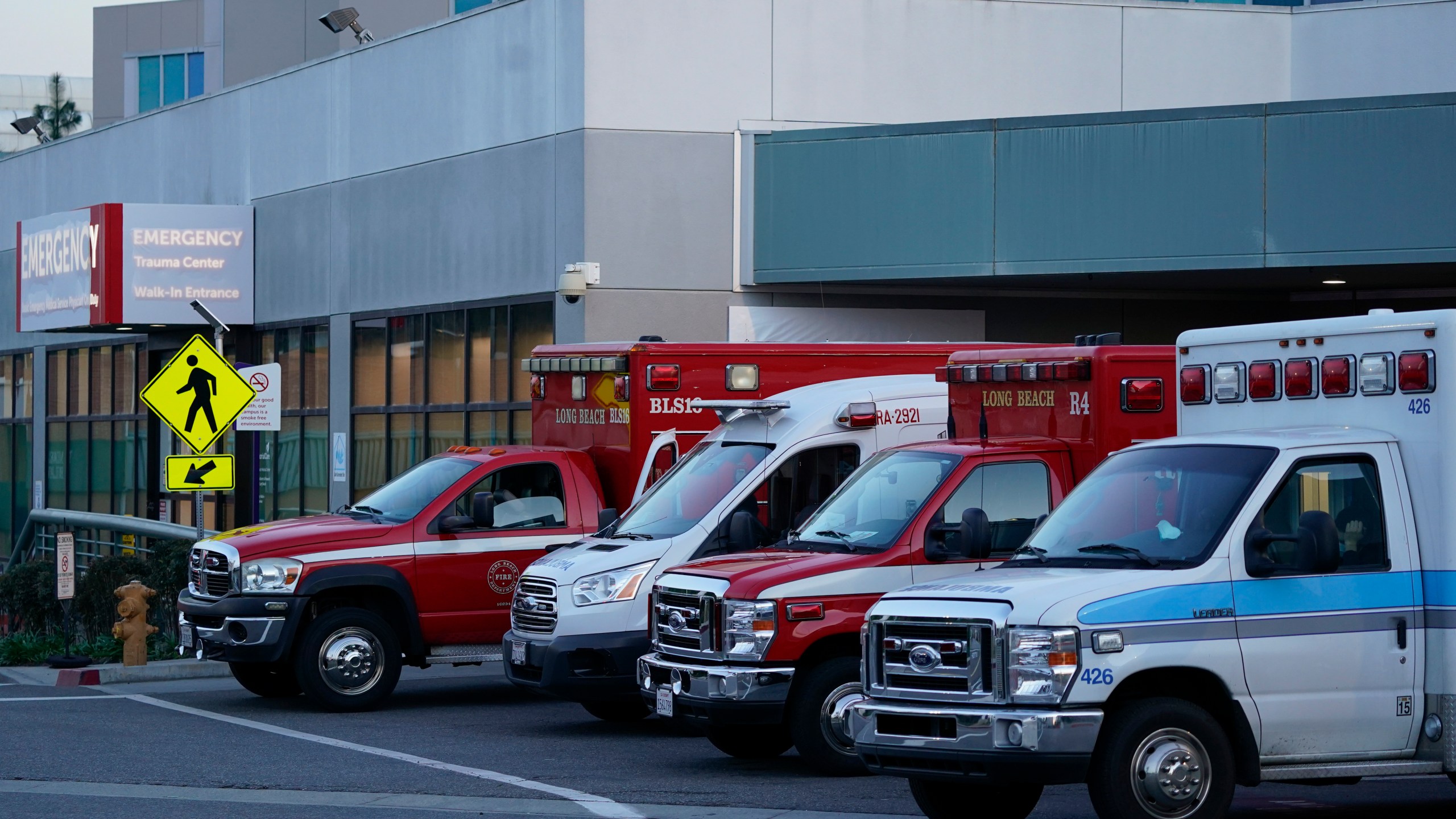 Ambulances are parked outside an emergency room entrance at Long Beach Medical Center Tuesday, Jan. 5, 2021, in Long Beach, Calif. (AP Photo/Ashley Landis)