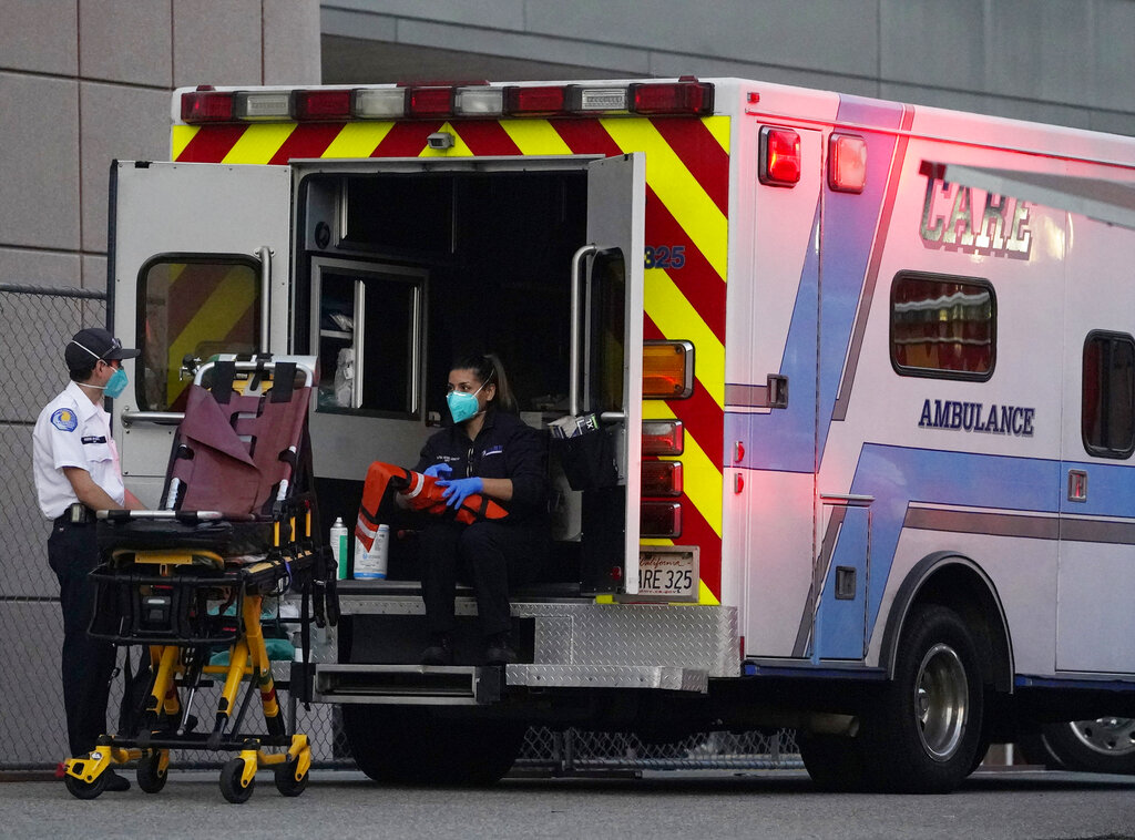 Emergency medical technicians sanitize their ambulance after transporting a patient at Los Angeles County + USC Medical Center in Los Angeles on Jan. 5, 2021. (AP Photo/Damian Dovarganes)