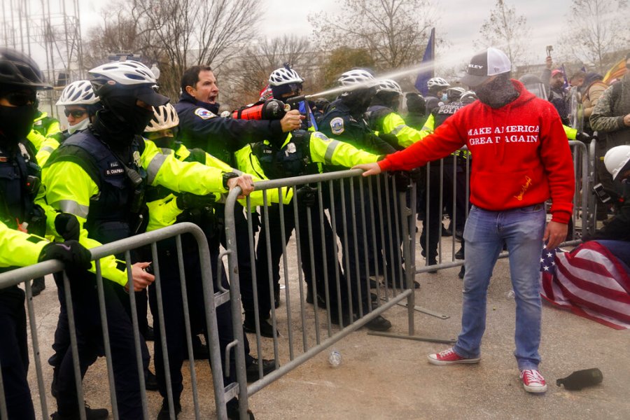 Demonstators loyal to President Donald Trump, are sprayed by police, Wednesday, Jan. 6, 2021, during a day of rioting at the Capitol. (AP Photo/John Minchillo)