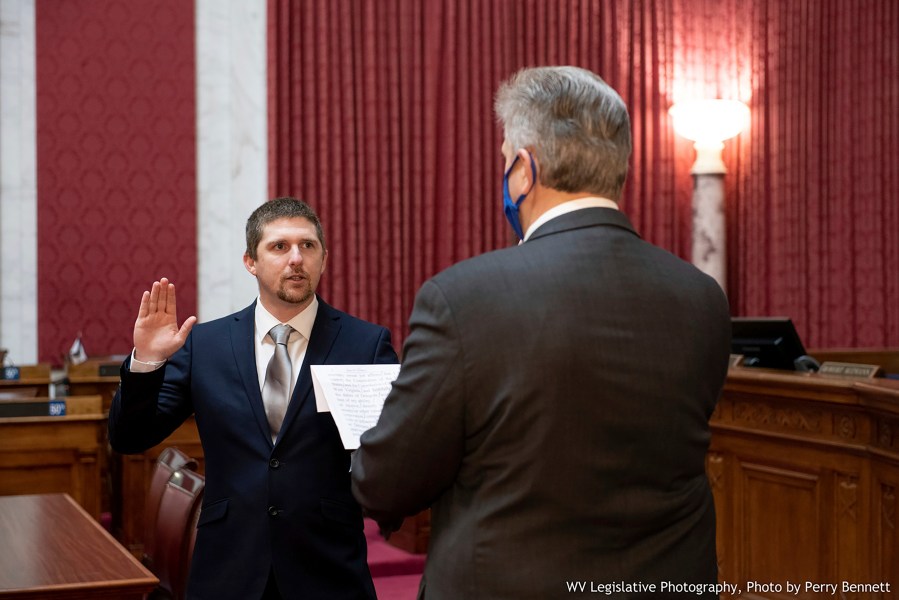 West Virginia House of Delegates member Derrick Evans, left, is given the oath of office Dec. 14, 2020, in the House chamber at the state Capitol in Charleston, W.Va. Evans recorded video of himself and fellow supporters of President Donald Trump storming the U.S. Capitol in Washington, D.C., on Wednesday, Jan. 6, 2021 prompting calls for his resignation and thousands of signatures on an online petition advocating his removal. (Perry Bennett/West Virginia Legislature via AP)