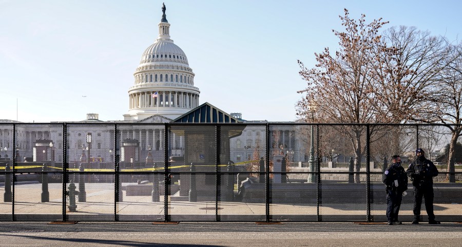 Capitol police officers stand outside of fencing that was installed around the exterior of the Capitol grounds on Jan. 7, 2021, in Washington. (AP Photo/John Minchillo)