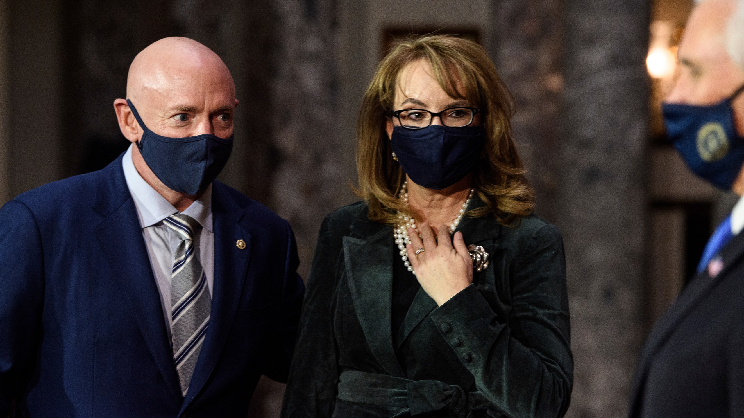 In this Dec. 2, 2020, file photo, Sen. Mark Kelly, D-Ariz., talks with his wife former Rep. Gabby Giffords, D-Ariz., and Vice President Mike Pence after participating in a re-enactment of his swearing-in on Capitol Hill in Washington. As a mob laid siege to the U.S. Capitol this week, former Rep. Gabby Giffords could only wait nervously for news about her husband, Mark Kelly, who was barely a month into his job as a newly elected senator from Arizona. A decade earlier it was Kelly enduring the excruciating wait for news about Giffords, who was shot in the head in an attempted assassination that, like Wednesday's siege, shocked the nation and prompted a reckoning about the state of politics and discourse in the United States. (Nicholas Kamm/Pool via AP, File)