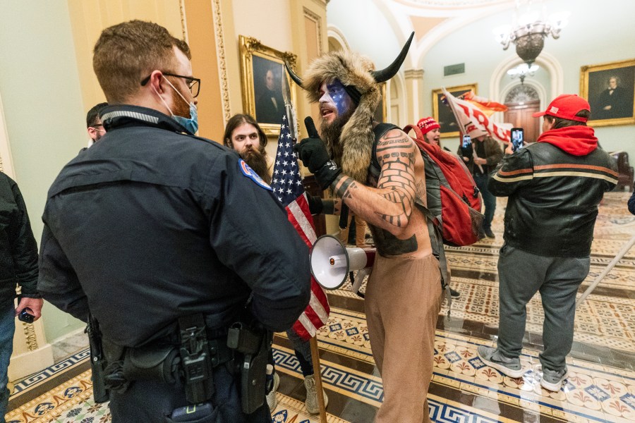 In this Jan. 6, 2021, file photo supporters of President Donald Trump are confronted by U.S. Capitol Police officers outside the Senate Chamber inside the Capitol in Washington. An Arizona man seen in photos and video of the mob wearing a fur hat with horns was also charged Saturday in Wednesday's chaos. Jacob Anthony Chansley, who also goes by the name Jake Angeli, was taken into custody Saturday, Jan. 9. (AP Photo/Manuel Balce Ceneta, File)