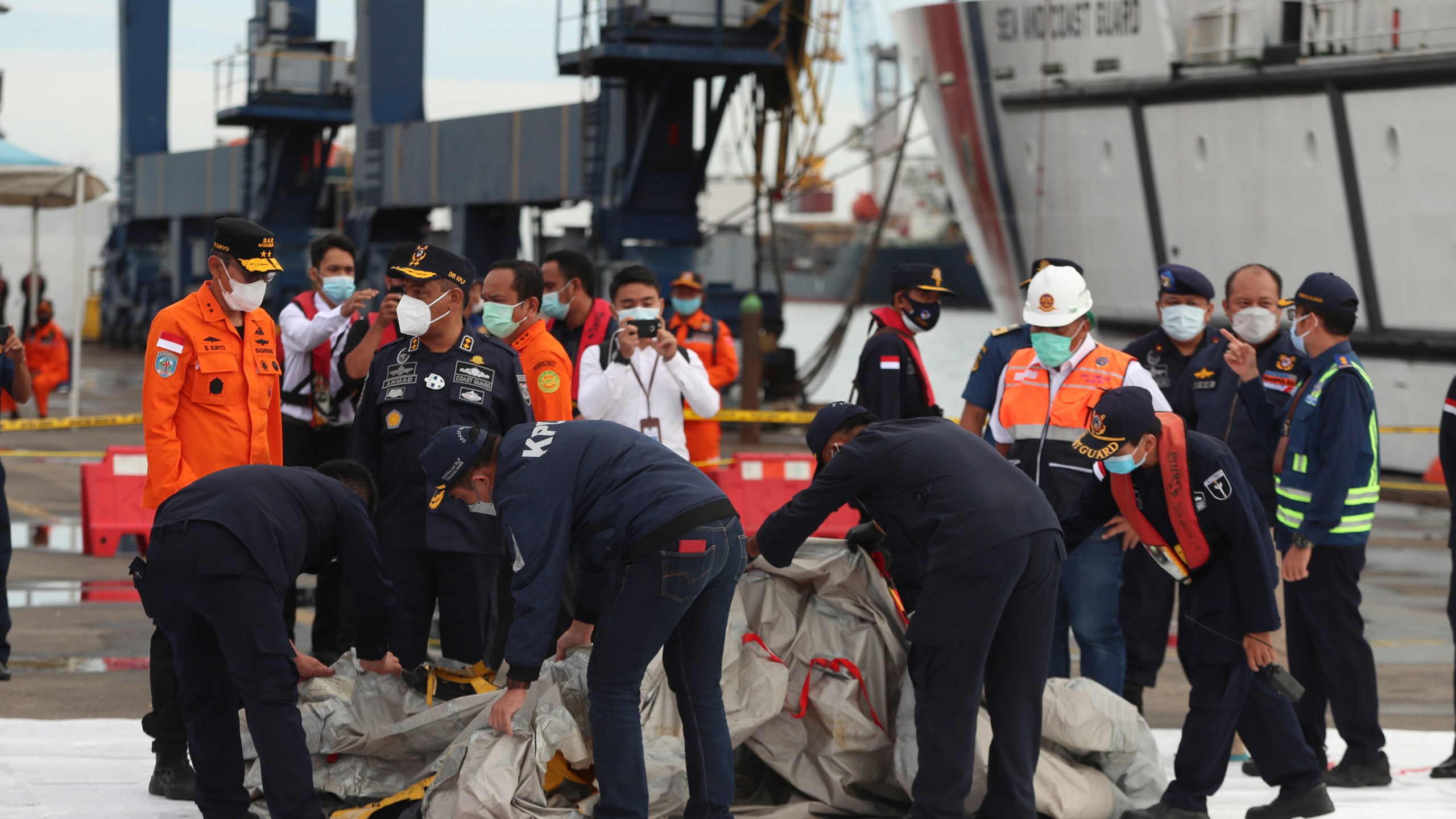 Rescuers inspect debris found in the waters around the location where a Sriwijaya Air passenger jet has lost contact with air traffic controllers shortly after the takeoff, at the search and rescue command center at Tanjung Priok Port in Jakarta, Indonesia, Sunday, Jan. 10, 2021. (AP Photo/Achmad Ibrahim)