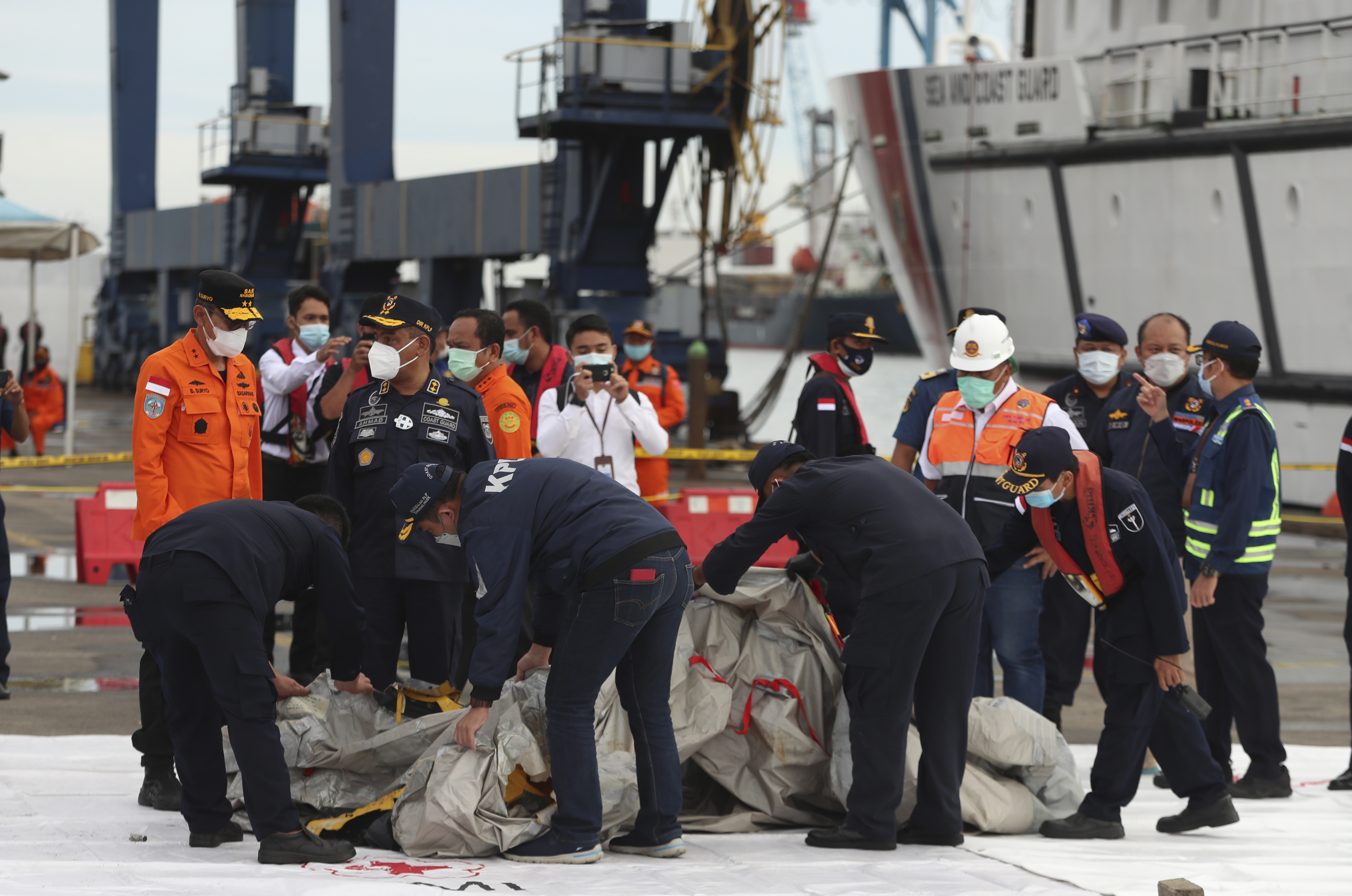 Rescuers inspect debris found in the waters around the location where a Sriwijaya Air passenger jet has lost contact with air traffic controllers shortly after the takeoff, at the search and rescue command center at Tanjung Priok Port in Jakarta, Indonesia, Sunday, Jan. 10, 2021. (AP Photo/Achmad Ibrahim)