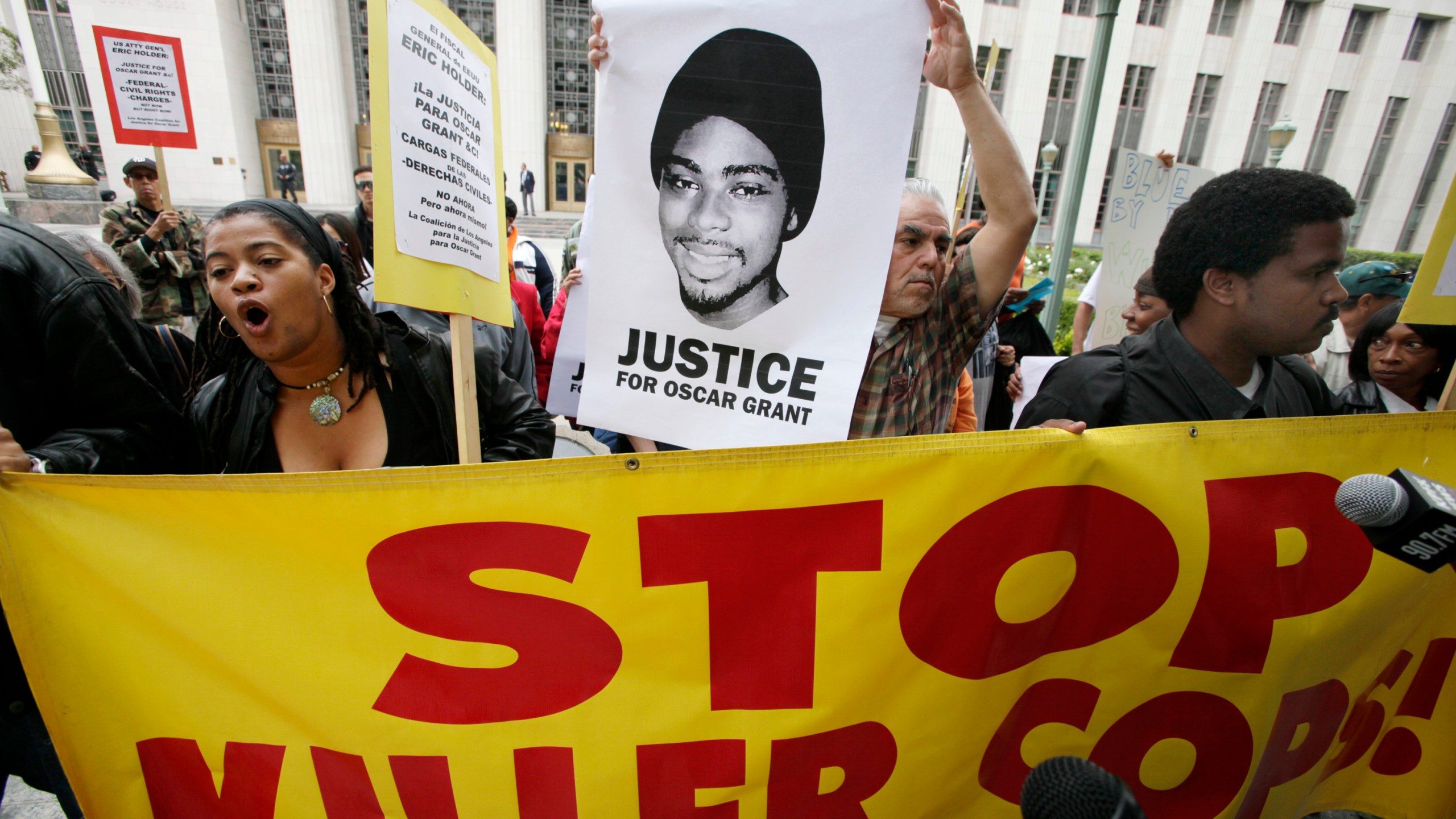 In this June 13, 2011, file photo protesters gather at the the U.S. District Court building in Los Angeles on behalf of shooting victim Oscar Grant. (AP Photo/Nick Ut, file)