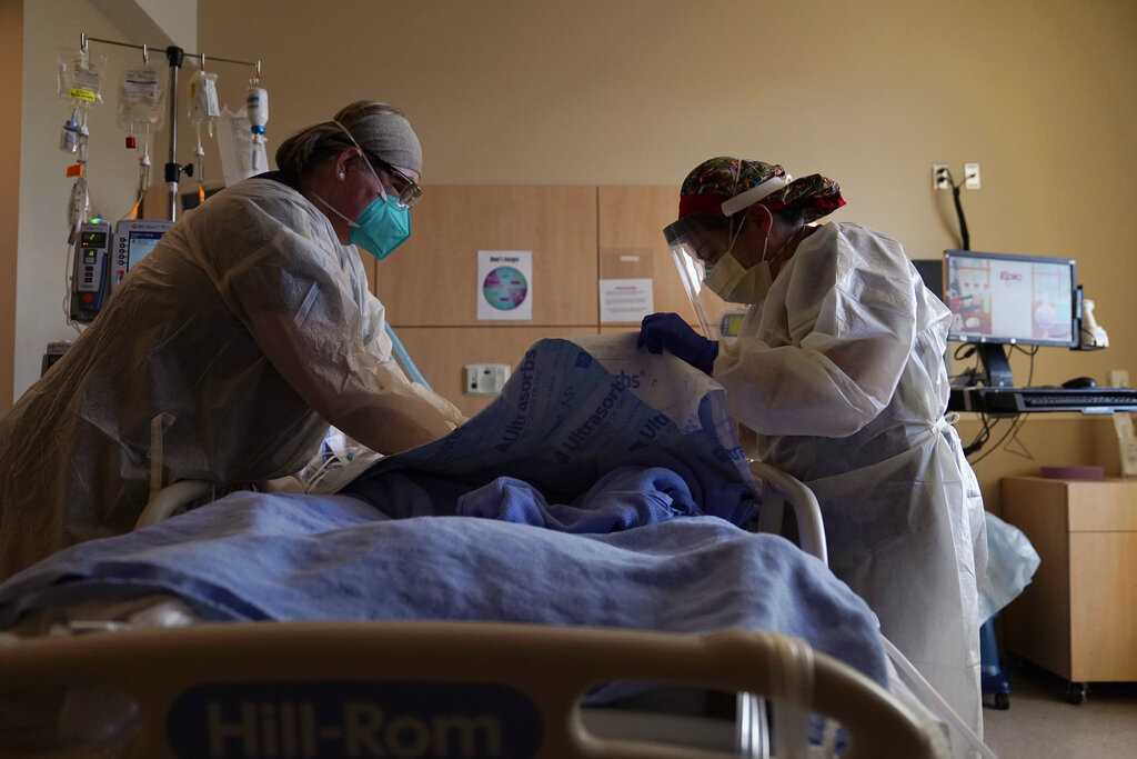 In this Dec. 22, 2020, file photo, registered nurses Robin Gooding, left, and Johanna Ortiz treat a COVID-19 patient at Providence Holy Cross Medical Center in the Mission Hills section of Los Angeles. (AP Photo/Jae C. Hong, File)