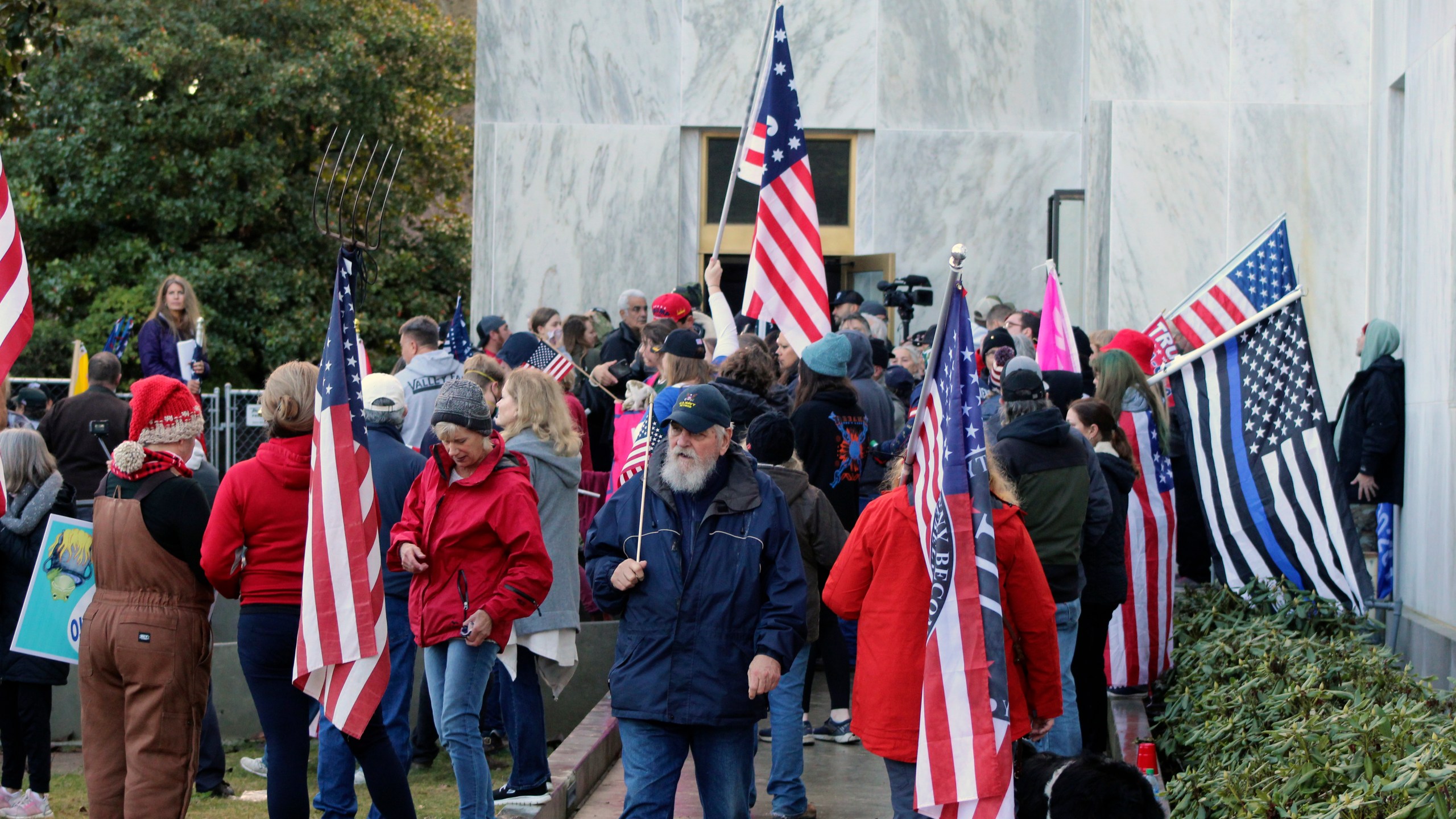 In this Dec. 21, 2020, file photo, pro-Trump and anti-mask demonstrators hold a rally outside the Oregon State Capitol as legislators meet for an emergency session in Salem, Ore. During the protest Republican lawmaker, Rep. Mike Nearman, physically opened the Capitol's door — letting protesters, who clashed with police, gain access to the building. There have been calls for Nearman to resign ahead of the upcoming 2021 Legislative session that begins Tuesday, Jan. 19, 2021. (AP Photo/Andrew Selsky, File)