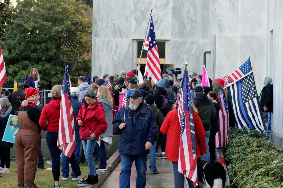 In this Dec. 21, 2020, file photo, pro-Trump and anti-mask demonstrators hold a rally outside the Oregon State Capitol as legislators meet for an emergency session in Salem, Ore. During the protest Republican lawmaker, Rep. Mike Nearman, physically opened the Capitol's door — letting protesters, who clashed with police, gain access to the building. There have been calls for Nearman to resign ahead of the upcoming 2021 Legislative session that begins Tuesday, Jan. 19, 2021. (AP Photo/Andrew Selsky, File)