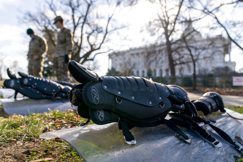 The Dome of the Capitol building is visible as members of the National Guard stand in front of riot gear laid out on a field on Capitol Hill in Washington, Wednesday, Jan. 13, 2021. (AP Photo/Andrew Harnik)