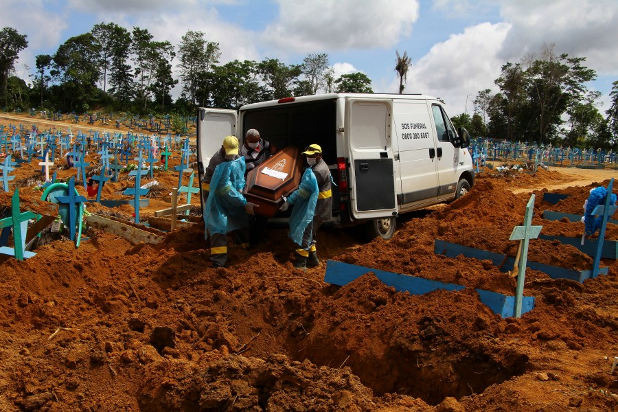 In this Jan. 6, 2021, file photo, cemetery workers carry the remains of 89-year-old Abilio Ribeiro, who died of the coronavirus, to bury at the Nossa Senhora Aparecida cemetery in Manaus, Amazonas state, Brazil. (AP Photo/Edmar Barros)