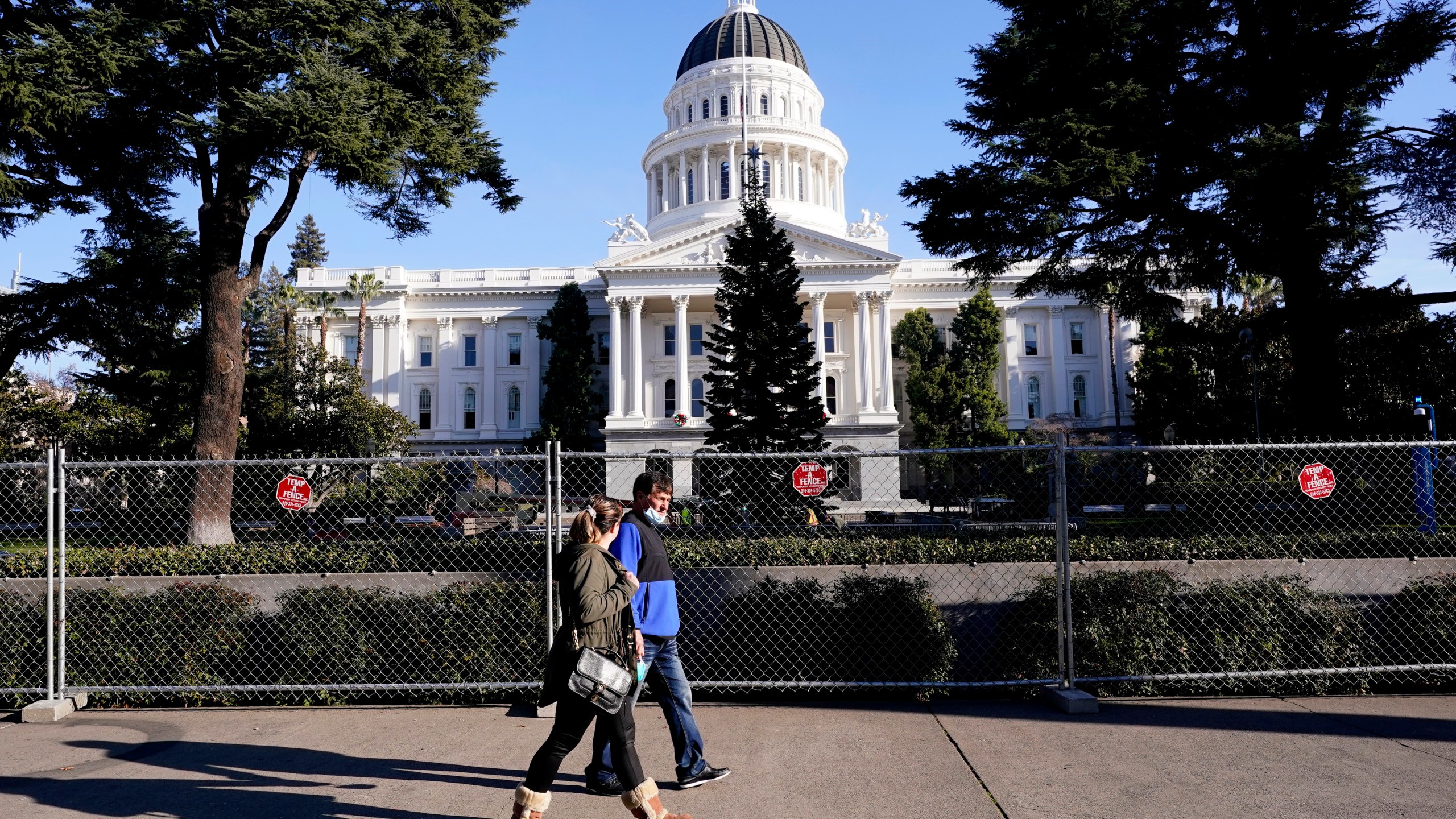 A temporary six-foot high chain link fence surrounds the state Capitol because of concerns over the potential for civil unrest, in Sacramento, Calif., Thursday, Jan. 14, 2021. (AP Photo/Rich Pedroncelli)