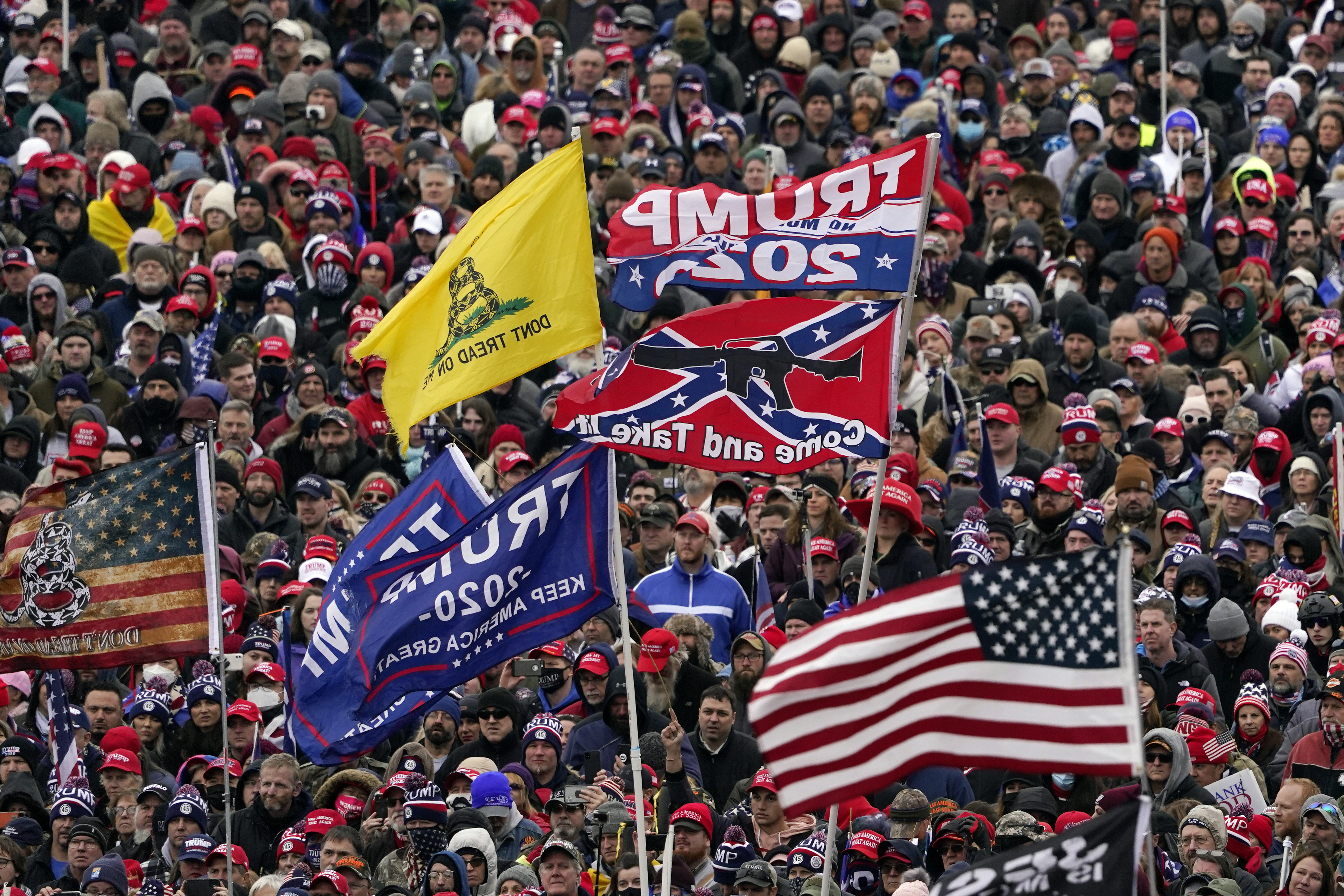 In this Wednesday, Jan. 6, 2021, file photo, supporters listen as President Donald Trump speaks as a Confederate-themed and other flags flutter in the wind during a rally in Washington. (AP Photo/Evan Vucci, File)