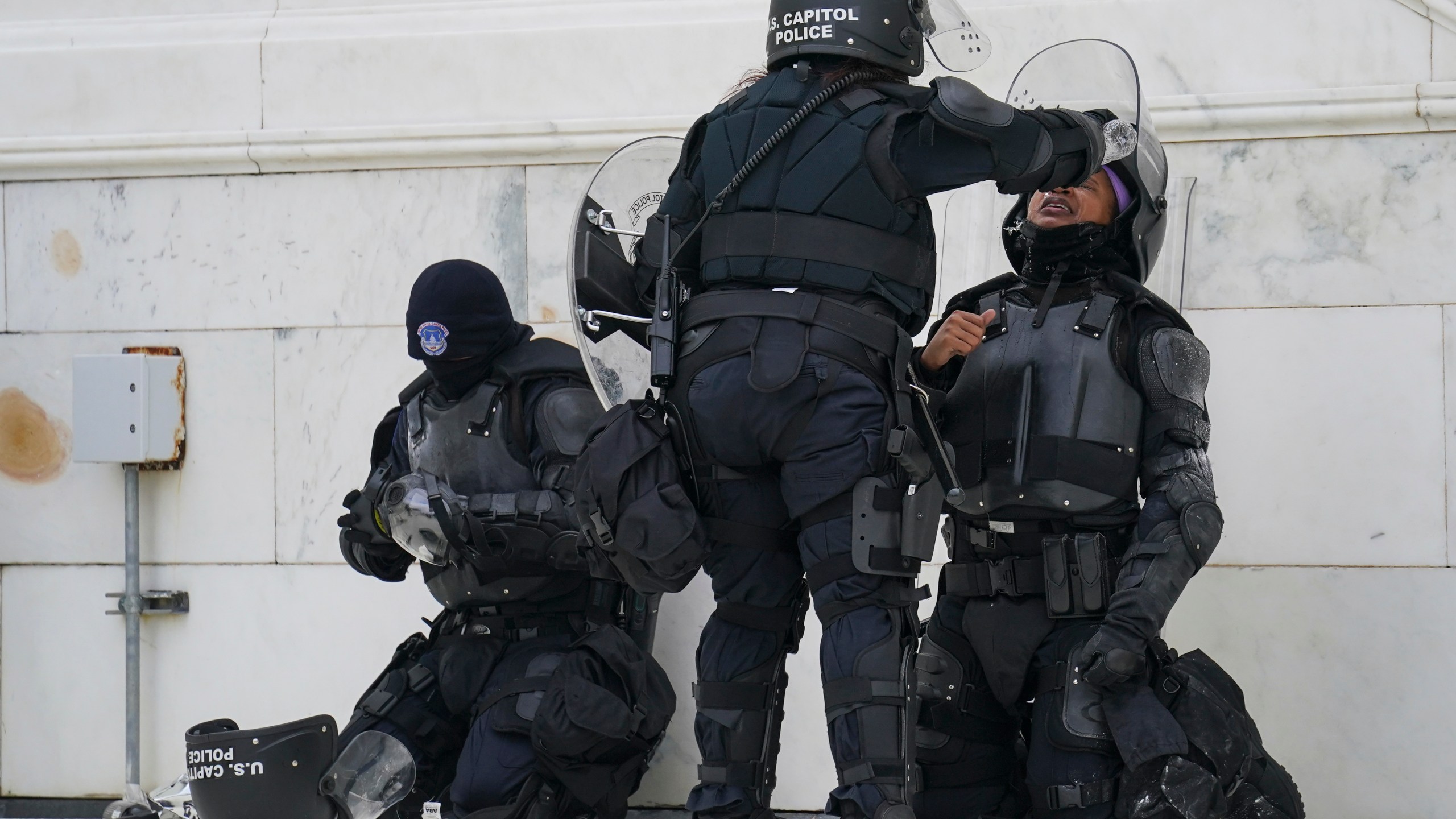 A police officer has eyes flushed with water after a confrontation with rioters at the Capitol in Washington on Jan. 6, 2021. (AP Photo/John Minchillo)