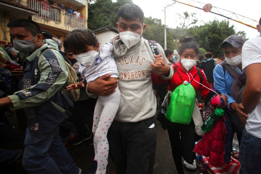 Honduran migrants hoping to reach the U.S. cross the border patrolled by Guatemalan soldiers, in El Florido, Guatemala, Saturday, Jan. 16, 2021. (AP Photo/Sandra Sebastian)