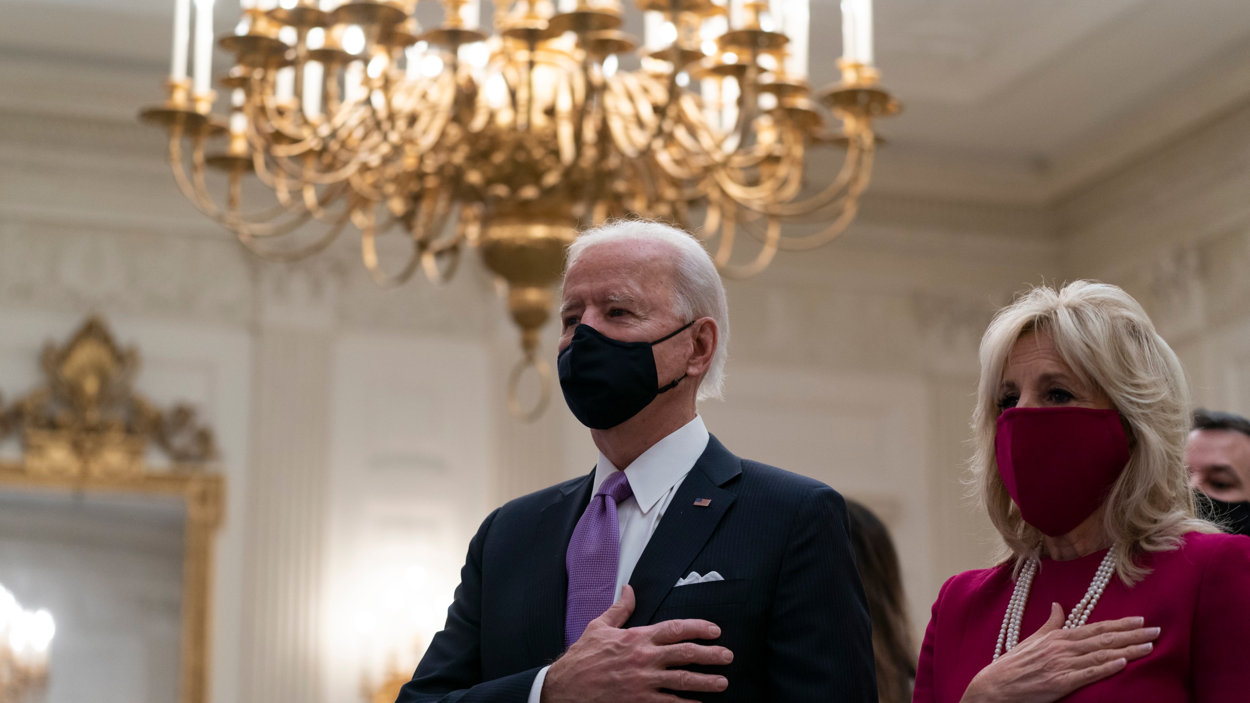 President Joe Biden, accompanied by first lady Jill Biden, places his hand over his heart during a performance of the national anthem, during a virtual Presidential Inaugural Prayer Service in the State Dinning Room of the White House, Thursday, Jan. 21, 2021, in Washington. (AP Photo/Alex Brandon)