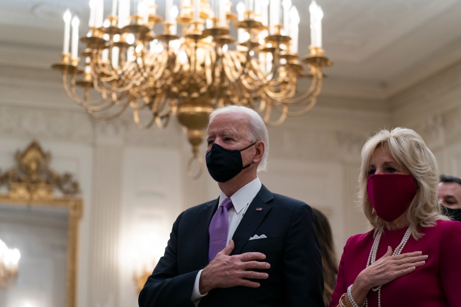 President Joe Biden, accompanied by first lady Jill Biden, places his hand over his heart during a performance of the national anthem, during a virtual Presidential Inaugural Prayer Service in the State Dinning Room of the White House, Thursday, Jan. 21, 2021, in Washington. (AP Photo/Alex Brandon)