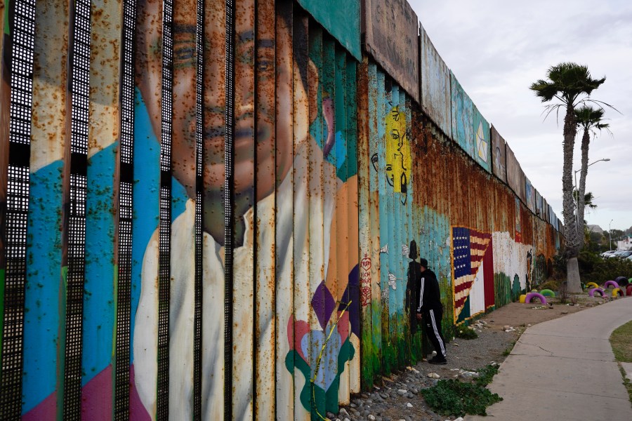 A man looks through the first wall at Friendship Park, near where the border separating Tijuana, Mexico, and San Diego meets the Pacific Ocean on Jan. 19, 2021, in Tijuana, Mexico. (Gregory Bull / Associated Press)