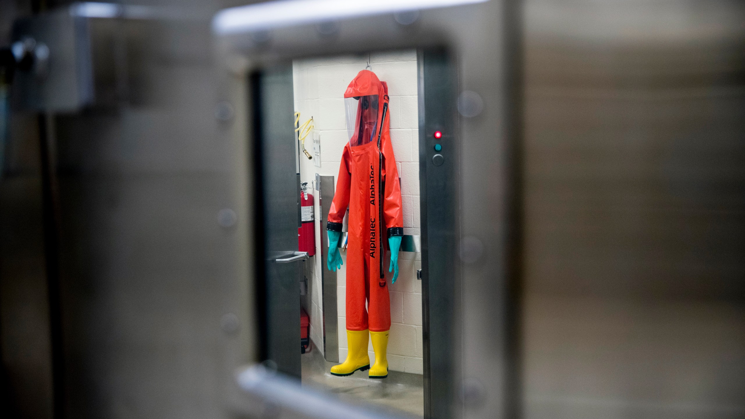 In this March 19, 2020, file photo, a biosafety protective suit for handling viral diseases are hung up in a biosafety level 4 training facility at U.S. Army Medical Research and Development Command at Fort Detrick in Frederick, Md., where scientists are working to help develop solutions to prevent, detect and treat the coronavirus. (AP Photo/Andrew Harnik)