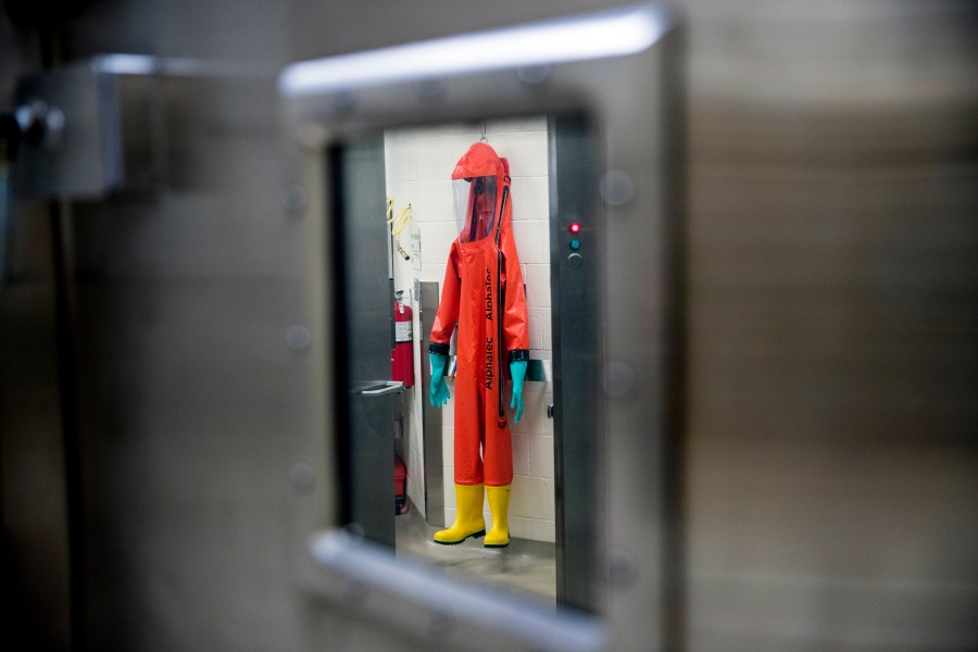 In this March 19, 2020, file photo, a biosafety protective suit for handling viral diseases are hung up in a biosafety level 4 training facility at U.S. Army Medical Research and Development Command at Fort Detrick in Frederick, Md., where scientists are working to help develop solutions to prevent, detect and treat the coronavirus. (AP Photo/Andrew Harnik)