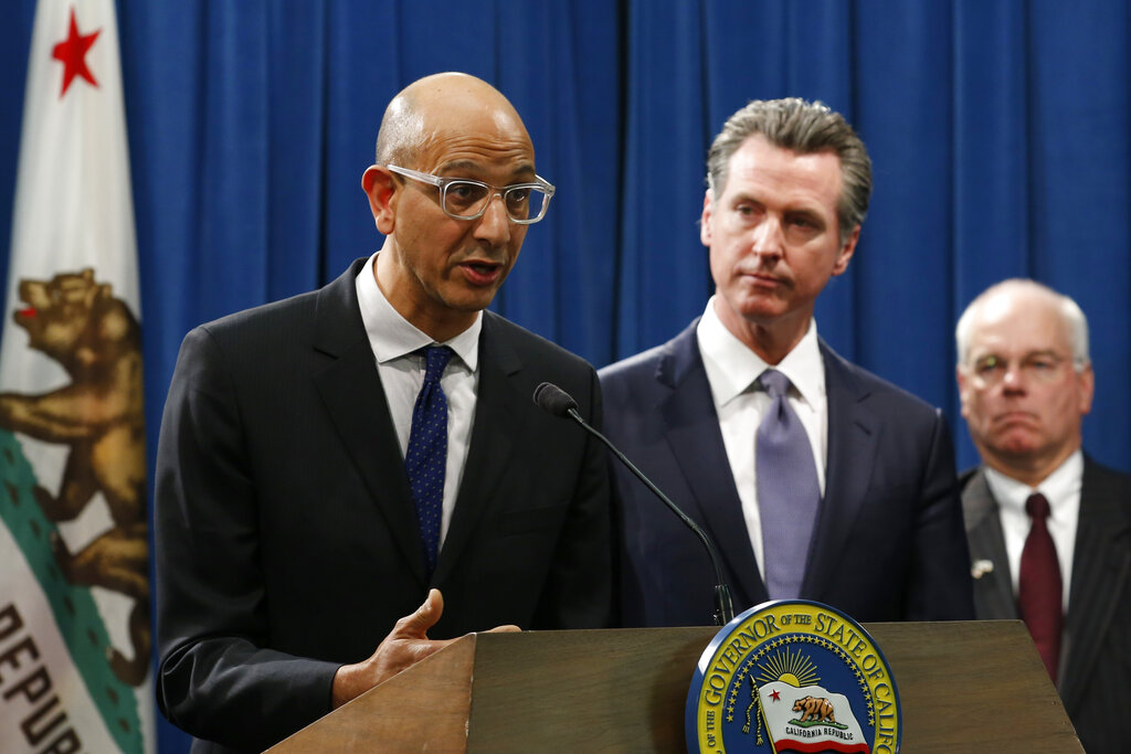 In this March 12, 2020, file photo Dr. Mark Ghaly, secretary of the California Health and Human Services, discusses the coronavirus as Gov. Gavin Newsom, center, listens at a news conference in Sacramento, Calif. (AP Photo/Rich Pedroncelli, File)