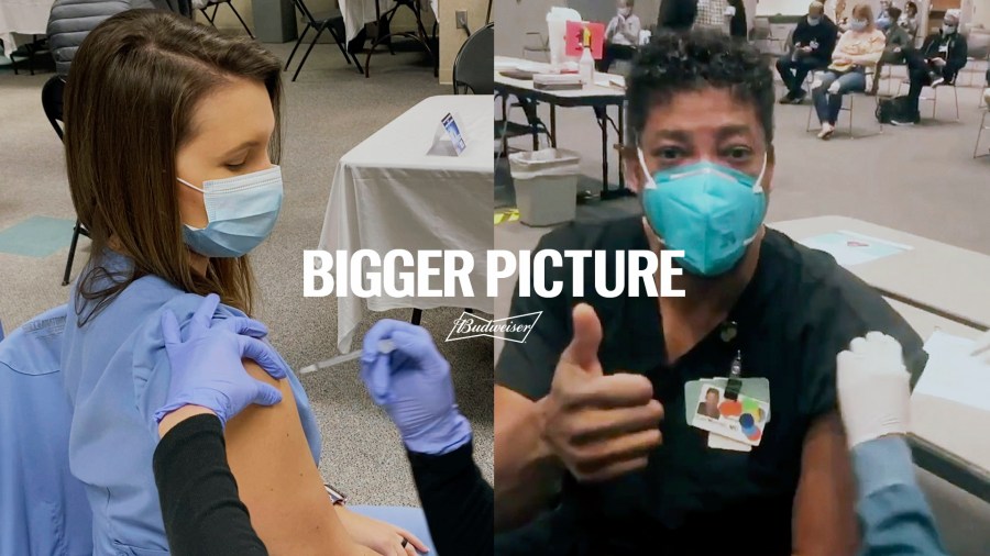 This image provided by Budweiser shows two health care workers getting vaccinated in an advertisement Budweiser is running before the Super Bowl. For the first time since 1983, when Anheuser-Busch used all of its ad time to introduce a beer called Bud Light, the beer giant isn't advertising its iconic Budweiser brand during the Super Bowl. Instead, it’s donating the money it would have spent on the ad to coronavirus vaccination awareness efforts.(Budweiser via AP)