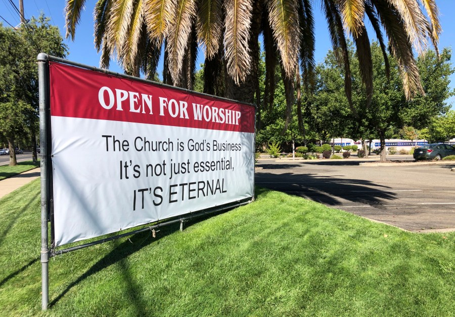 This July 9, 2020 file photo shows a banner reading: "Open for Worship, The Church is God's Business It's not just essential, It's Eternal," posted outside the Crossroads Community Church in Yuba City, Calif. (AP Photo/Adam Beam)