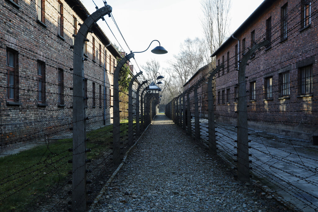 A pathway leading to an observation and security tower between what were electric barbed wire fences inside the former Nazi death camp of Auschwitz I in Oswiecim, Poland, Sunday, Dec. 8, 2019. (AP Photo/Markus Schreiber)