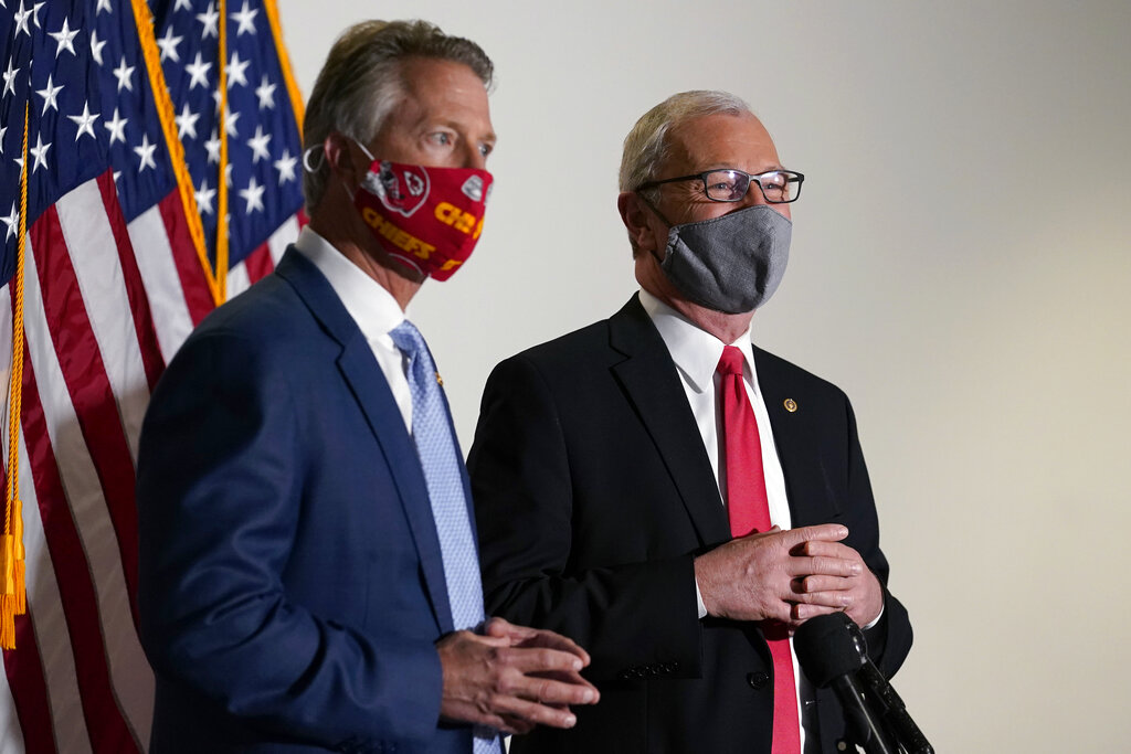 Sen. Roger Marshall, R-Kan., and Sen. Kevin Cramer, R-N.D., talk with reporters before a Republican policy luncheon on Capitol Hill in Washington, Tuesday, Jan. 26, 2021. (AP Photo/Susan Walsh)