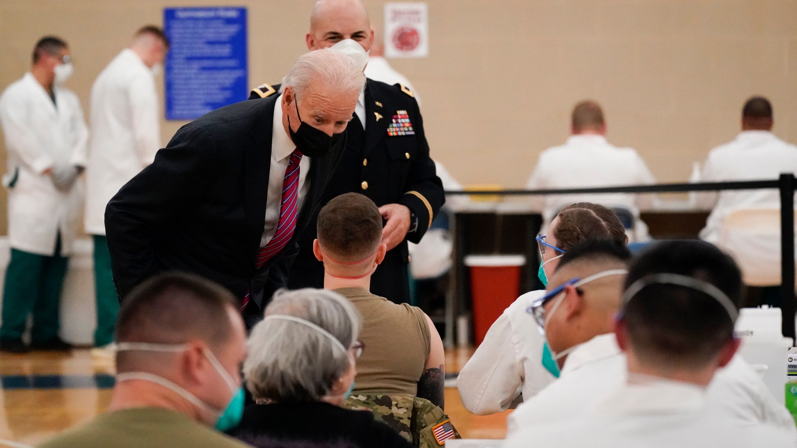 President Joe Biden speaks with a service member as he tours the COVID-19 vaccine center at Walter Reed National Military Medical Center with Col. Andrew Barr, director of Walter Reed on Jan. 29, 2021. (Alex Brandon/Associated Press)