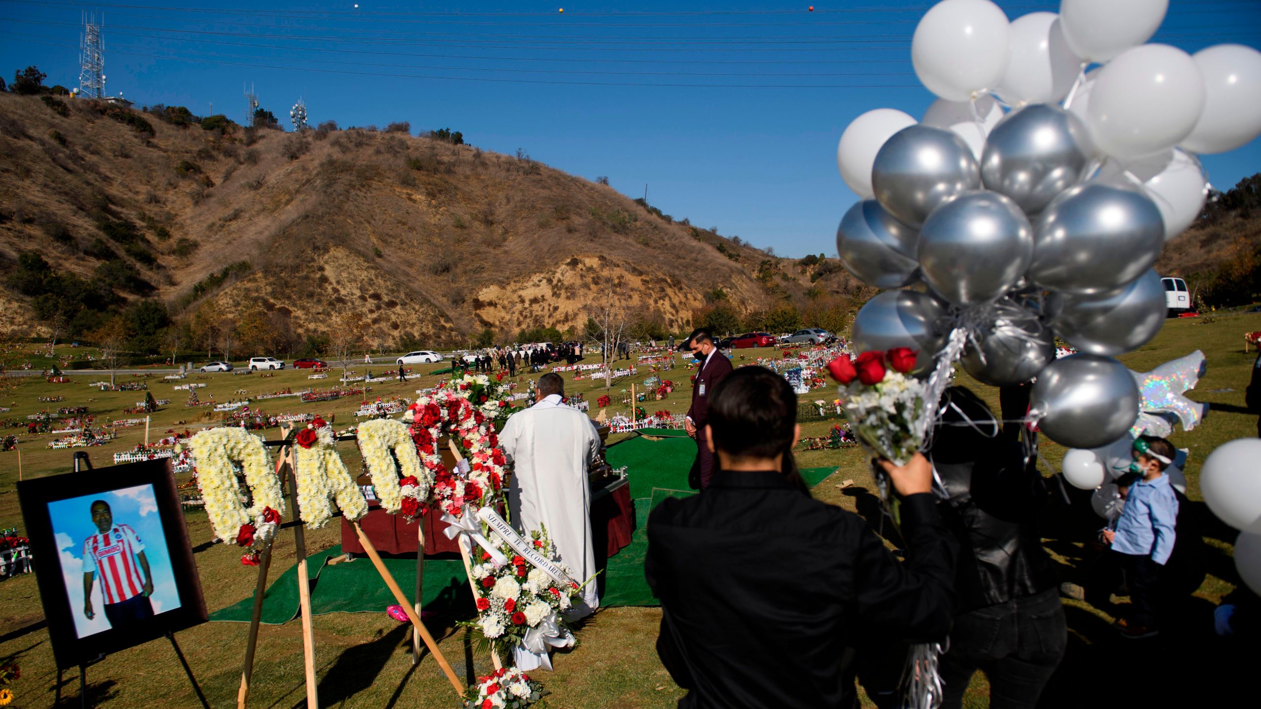 Family members mourn during a burial service for Gilberto Arreguin Camacho, 58, following his death due to COVID-19, at a cemetery on New Year's Eve, Dec. 31, 2020 in Whittier. (PATRICK T. FALLON/AFP via Getty Images)