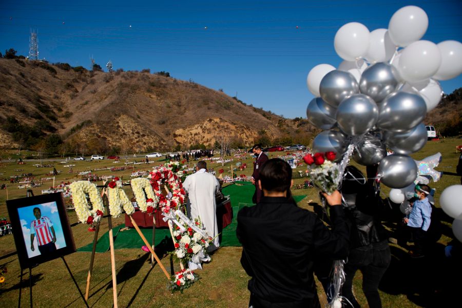 Family members mourn during a burial service for Gilberto Arreguin Camacho, 58, following his death due to COVID-19, at a cemetery on New Year's Eve, Dec. 31, 2020 in Whittier. (PATRICK T. FALLON/AFP via Getty Images)