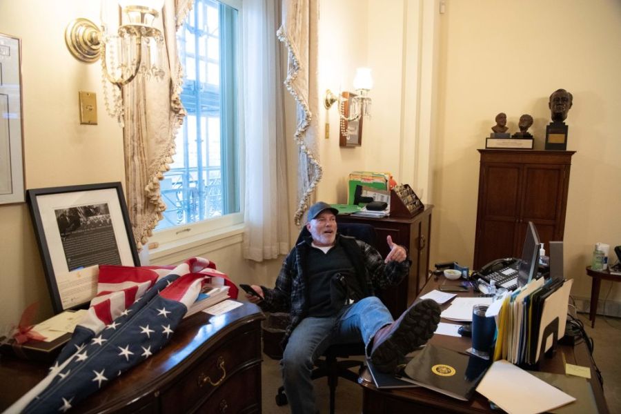 A supporter of President Donald Trump sits inside the office of US Speaker of the House Nancy Pelosi as he protest inside the US Capitol in Washington, DC, January 6, 2021. (SAUL LOEB/AFP via Getty Images)