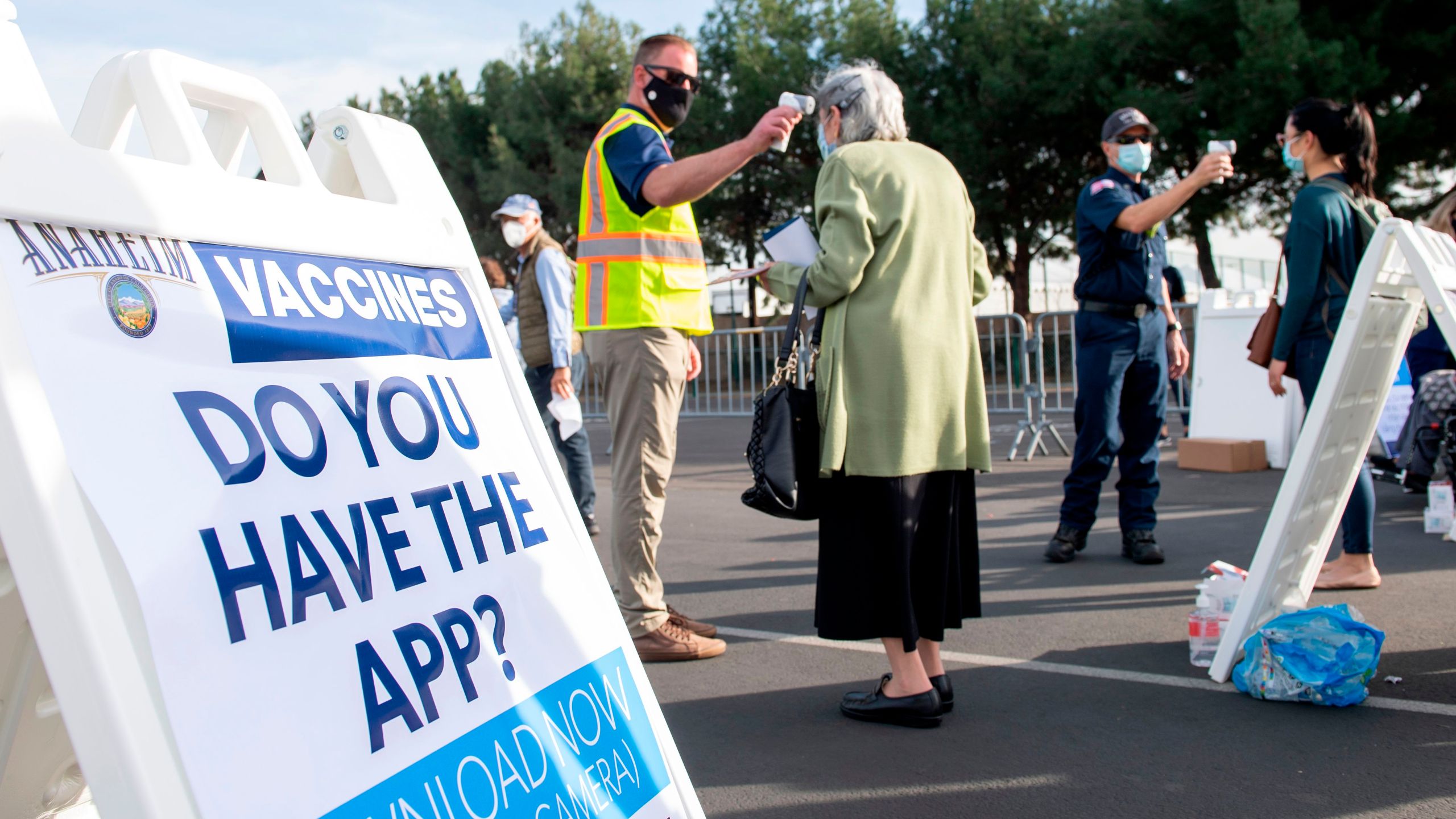 People have their temperatures checked as they arrive at a Disneyland parking lot to receive COVID-19 vaccines on the opening day of the Disneyland vaccination "super point-of-dispensing" (POD) site, on Jan. 13, 2021, in Anaheim. (VALERIE MACON/AFP via Getty Images)