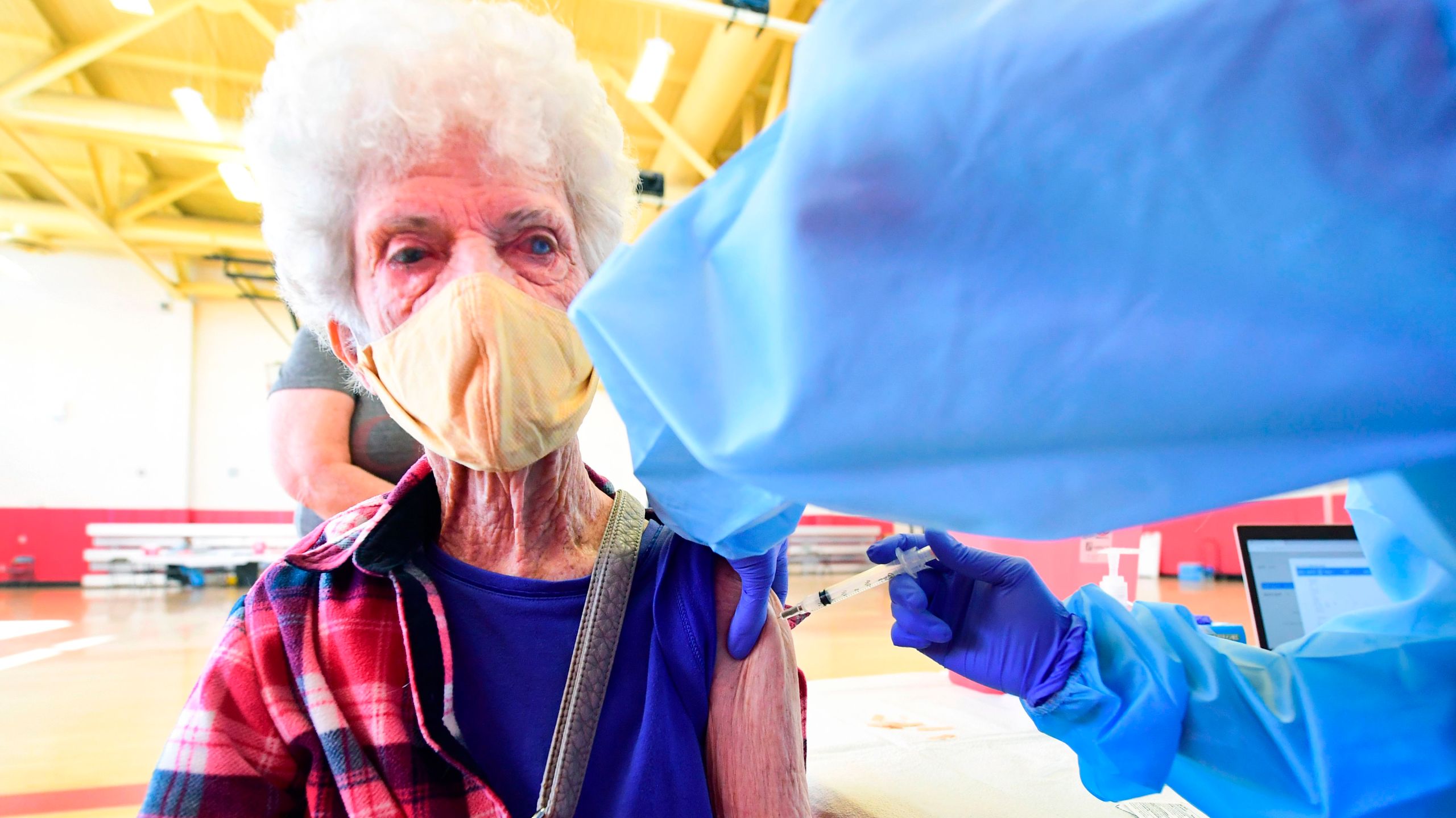 Beverly Goad, 89, receives her COVID-19 vaccine at the Corona High School gymnasium in the Riverside County city of Corona, California on January 15, 2021, a day after California began offering the coronavirus vaccine to residents 65 and older. (FREDERIC J. BROWN/AFP via Getty Images)