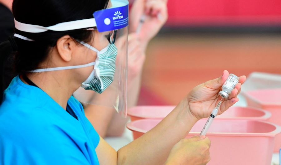 Registered nurses transfer the Moderna COVID-19 vaccine from a bottle into a syringe ready for vaccination at the Corona High School gymnasium in the Riverside County city of Corona, on Jan. 15, 2021. (FREDERIC J. BROWN/AFP via Getty Images)